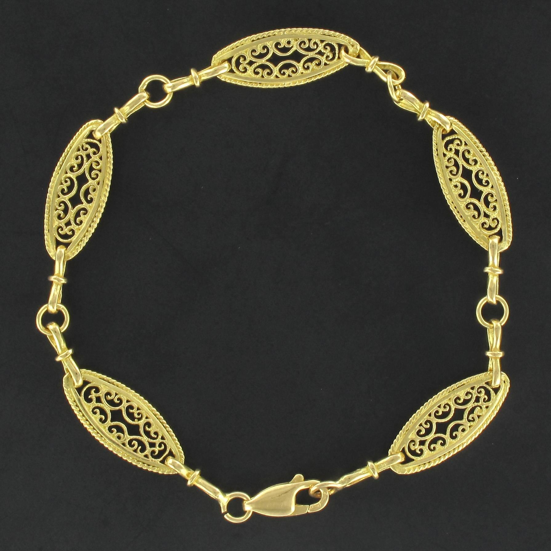 Bracelet in 18 carat yellow gold, eagle head hallmark. 

Composed of openwork links with filigree motives. The clasp is a spring ring. 

Overall length: 20 cm, width at the widest: 8.1 mm, thickness at the thickest: 3 mm.
Total weight: about 7.7