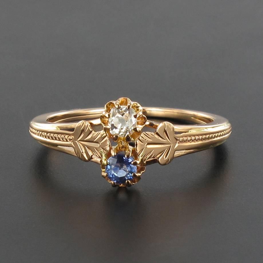 Ring in 18 carats rose gold.

Exquise antique ring, it is set with claws of an antique cushion cut diamond and a round sapphire. The whole is supported on either side of 2 x 1 sheet delicately chiselled which forms the starting point of the