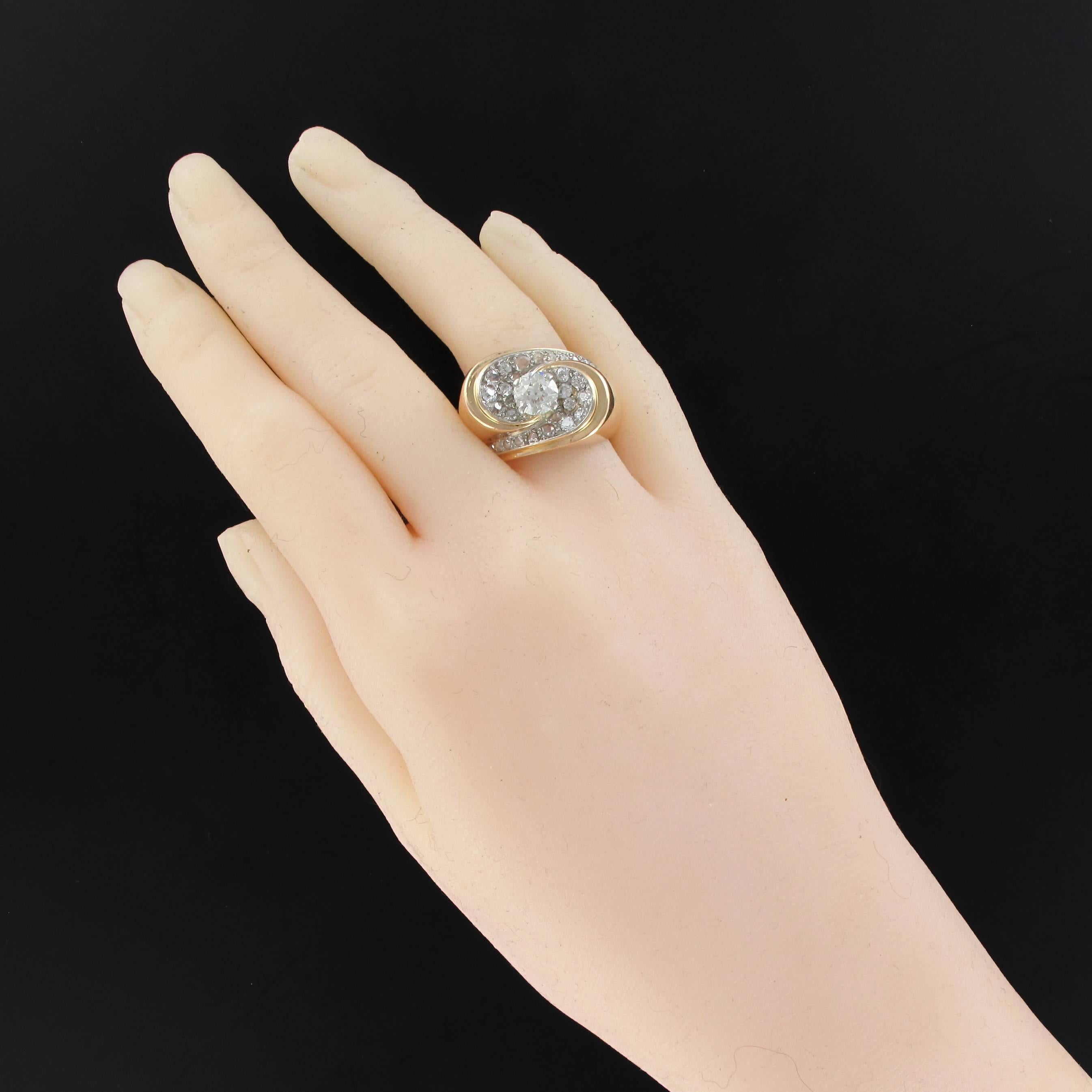 Platinium and 18 carats yellow gold ring.
Voluminous and incredible vintage ring, it is set with 4 claws on its top of an antique brilliant cut diamond on a concave asymetrical decor entirely set with brillant cut diamonds. The decoration is