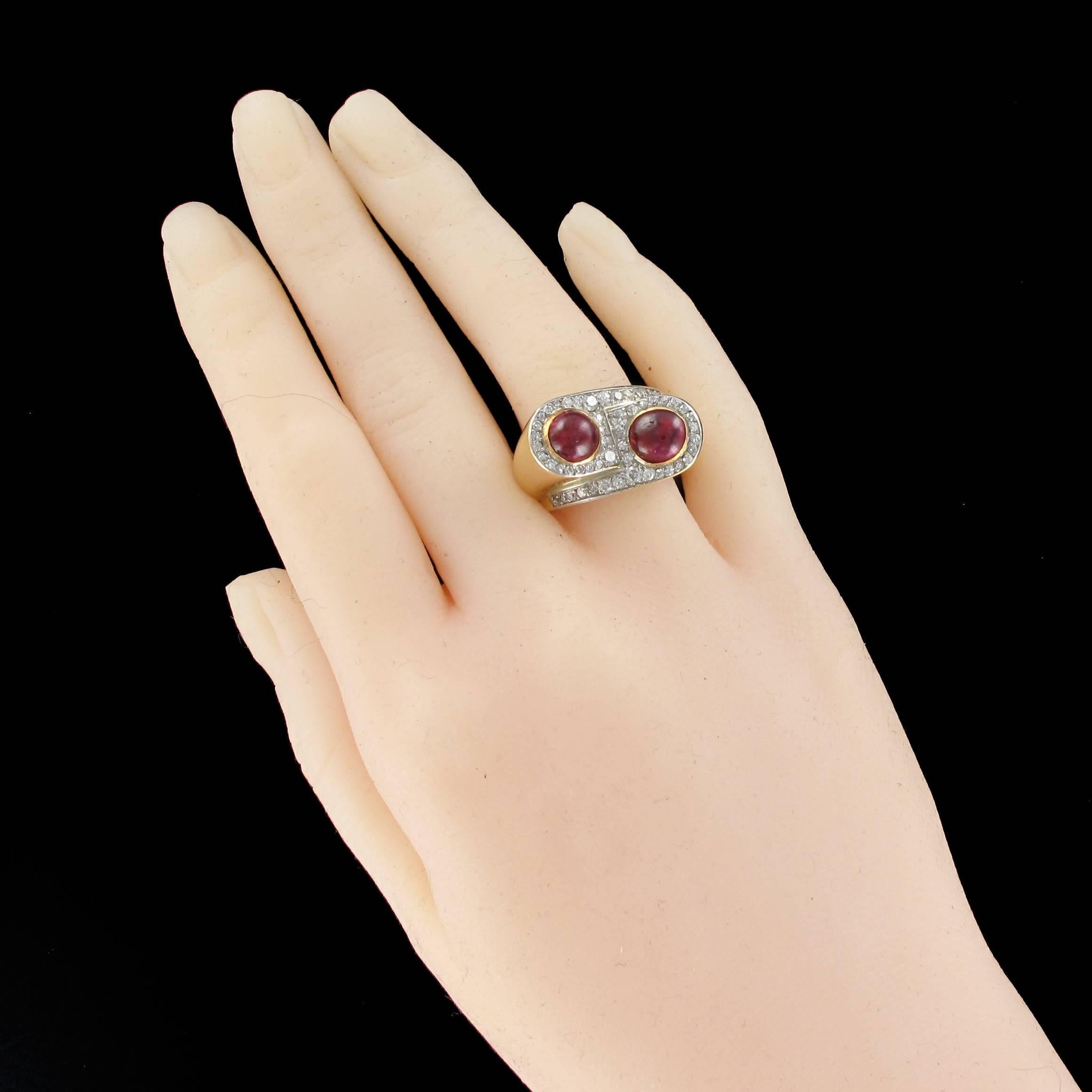 Ring in 18K yellow gold and platinum.

Featuring 2 crimped ruby cabochons in an asymmetric design sparkling with diamonds. 

Height: 1.37 cm, width: 2.2 cm, finger on height: 11 mm, ring width at the base: 5.5 mm.
Total weight of the ruby: 2.80