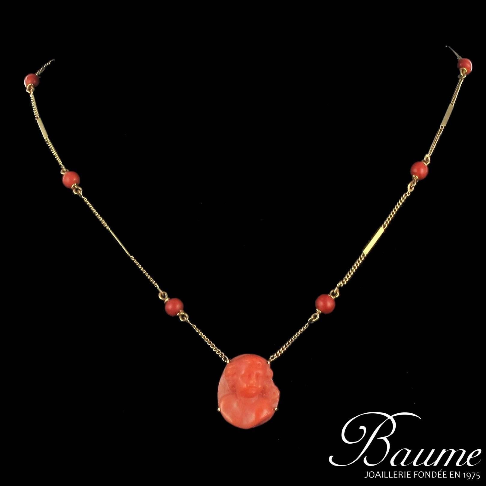 Pendant in 18 carat yellow gold, eagle head hallmark. 

This is composed of a curb link chain with alternating golden rods and red coral beads. The coral centrepiece features a cameo of a child’s face. 

Bead diameter: 4.3 mm, length: 48 cm,