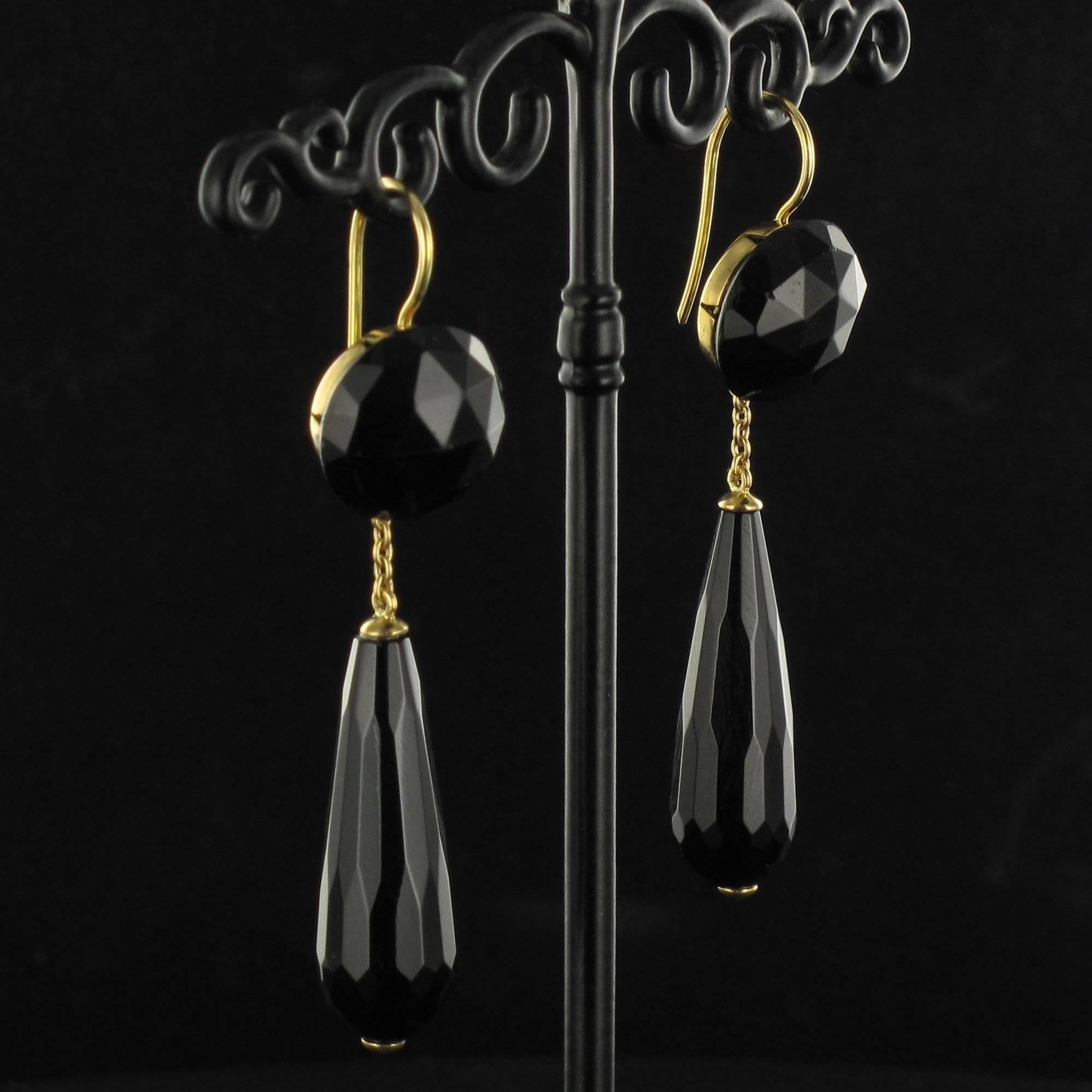 Baume creation - unique jewel.
 
Pair of 18 carat yellow gold earrings, eagle head hallmark.

Each earring features a flat circular facetted onyx bead on an openwork back from which is suspended a 7 gold link chain holding a pear cut onyx