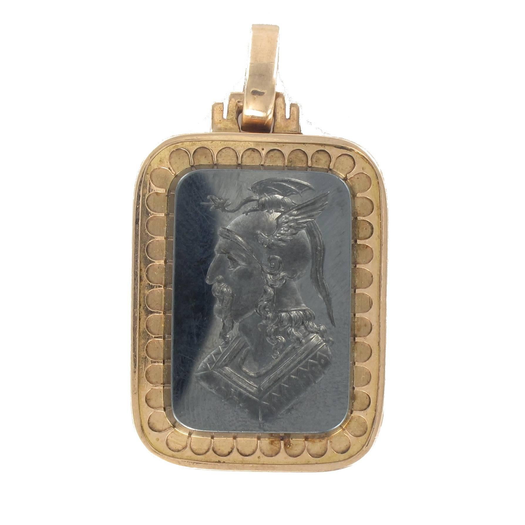 Pendant in 18 carat yellow gold, eagle head hallmark. 

In the form of a rectangle, this splendid and rare medallion pendant has a textured border with a sublime hematite intaglio displaying the profile of a bearded warrior wearing a winged helmet