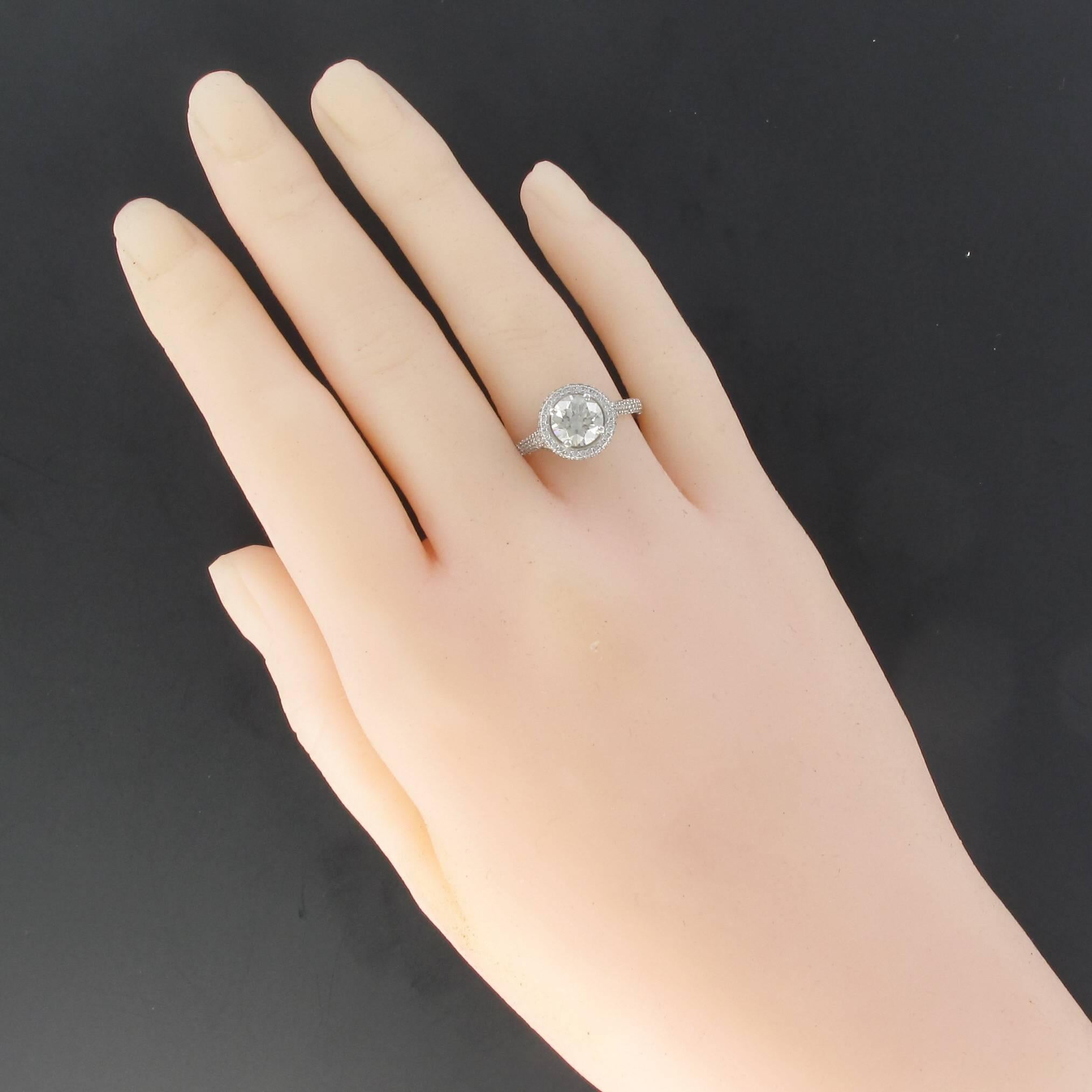 Platinum ring, dog's head hallmark.
Featuring a claw set central diamond surrounded by a diamond halo that continues onto the sides. The slightly elevated bed is set with diamonds and covers the entire frontal surface of the ring. 
Weight central