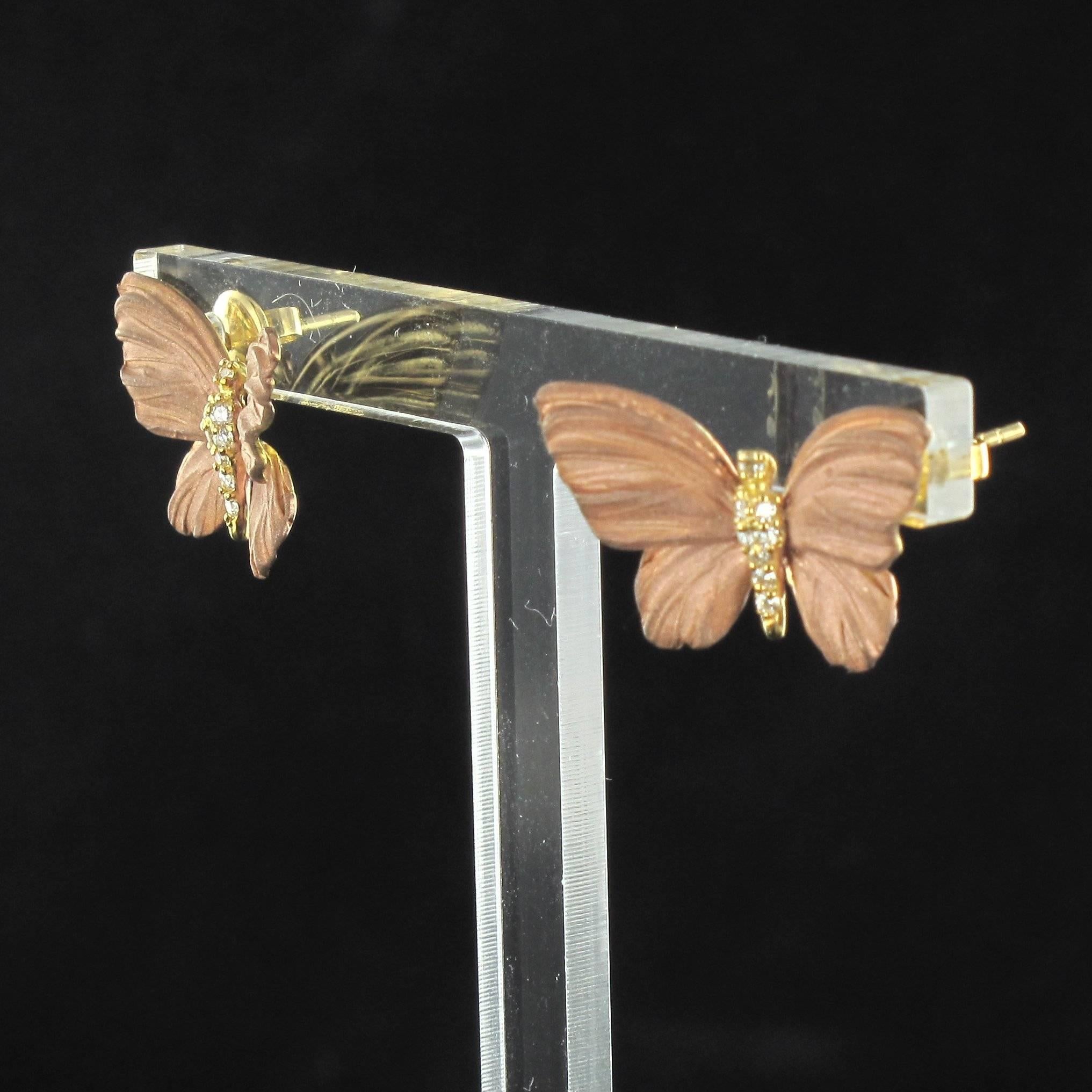 For pierced ears. 
Earrings in 18 carat yellow gold.

These earrings are in the form of butterflies in flight, the wings are beautifully reproduced in shades of glittering blue enamel. The bodies are covered in diamonds. The clasps are butterfly