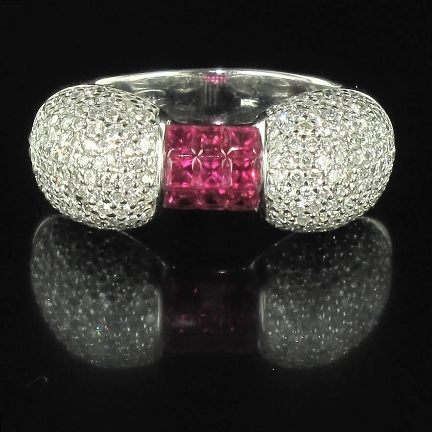 Ring in 18 carat white gold, eagle head hallmark. 

This splendid diamond and ruby ring features three rows of calibrated rubies in invisible settings that are shouldered with diamond pave. The ring bed is openwork. 

Height: 3 mm, width: 2.4