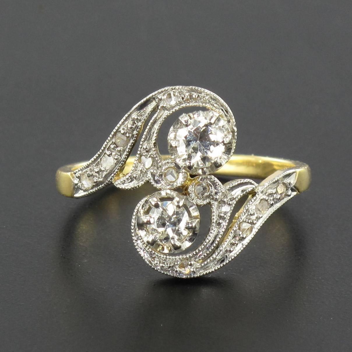Ring in 18 carat yellow and white gold, eagle head hallmark. 

This stupendous antique ring is claw set with 2 brilliant cut diamonds on a chiselled letter ‘S’ form that is set with small rose cut diamonds. 

Total weight of the 2 main diamonds