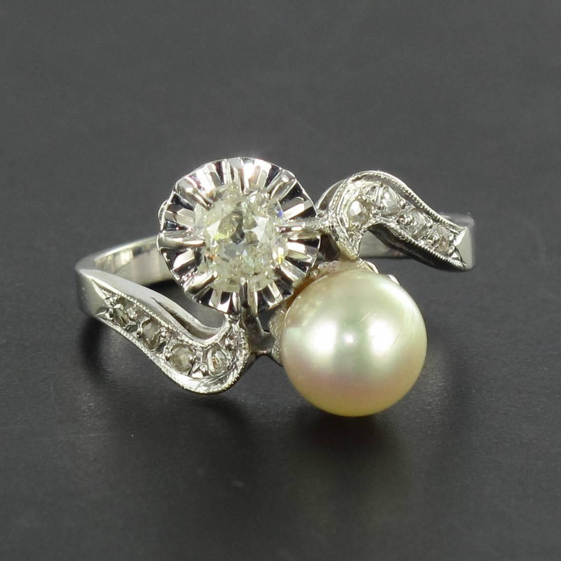 Ring in 18 carat white gold, eagle head hallmark. 

This splendid Lovers ring is set with a pale rose pink oriental cultured pearl and an antique cushion cut diamond. The beginning of the ring band at each side is formed of a beaded arabesque curl