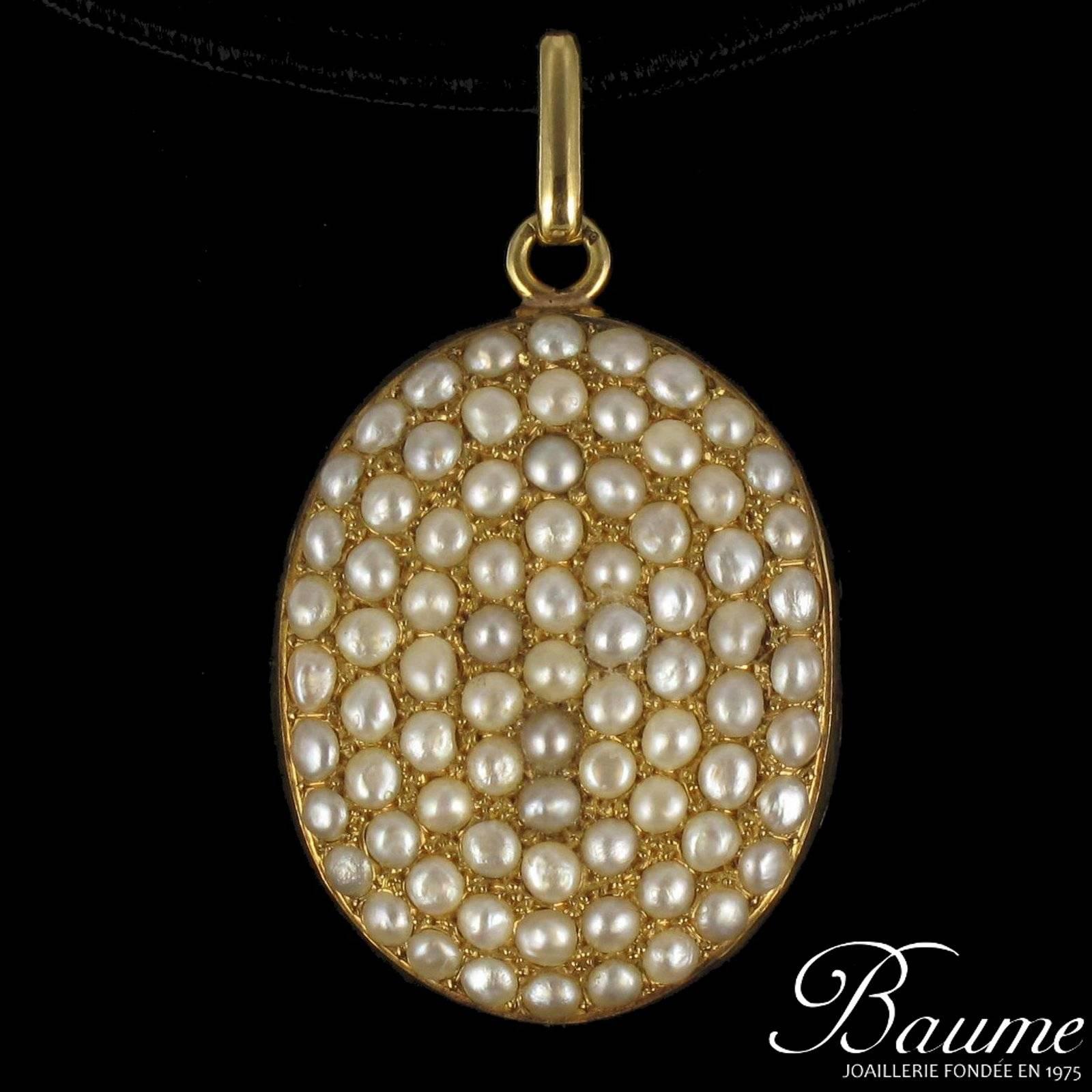 Pendant in 18 carat yellow gold. 

In the form of an oval this fine pearl pendant is set on the front with a multitude of fine half pearls. On the reverse side is an engraved  monogram in the form of M and T. It can be opened at the side with the