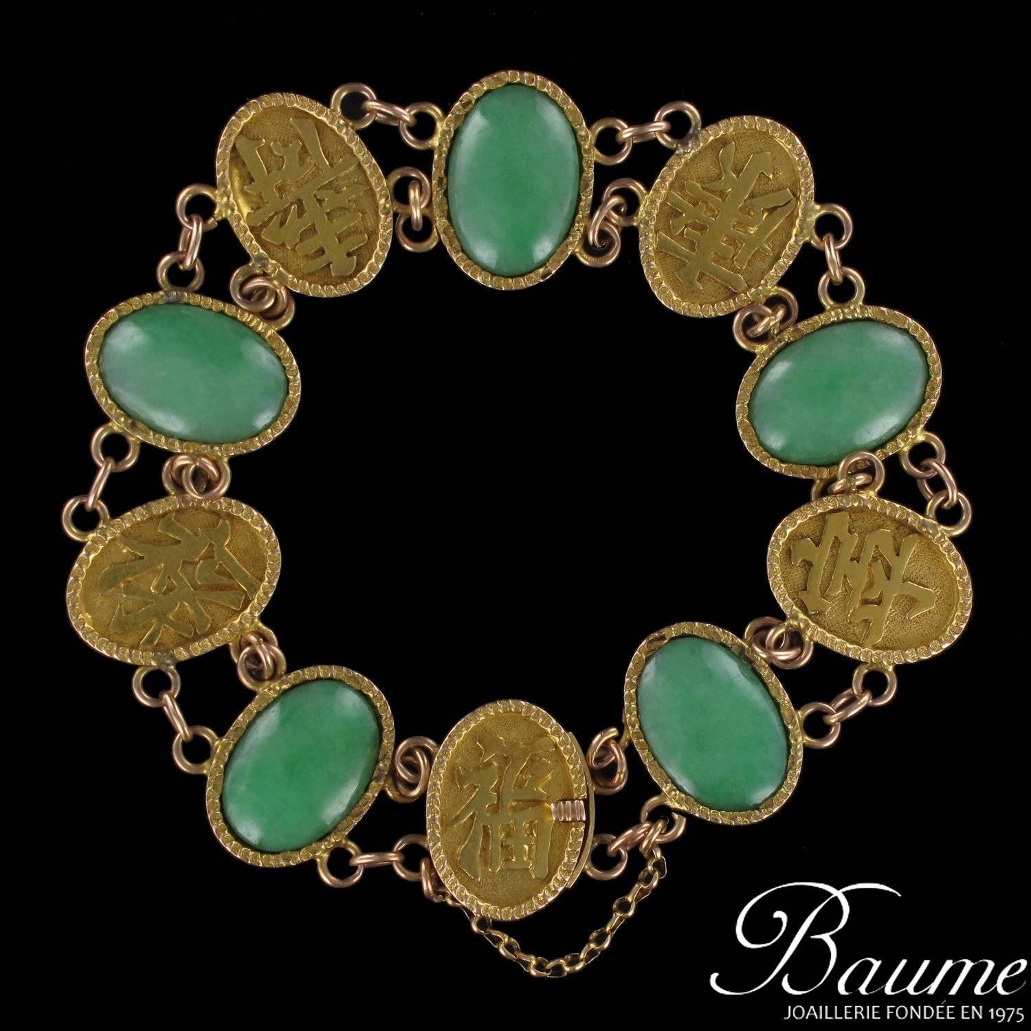 Bracelet in 18 karat yellow gold.
This splendid antique gold bracelet is composed of 5 bezel set oval green jade cabochons and 5 embossed calligraphic motifs on matt backgrounds of the same design. These are linked together with 2 chains. This jade