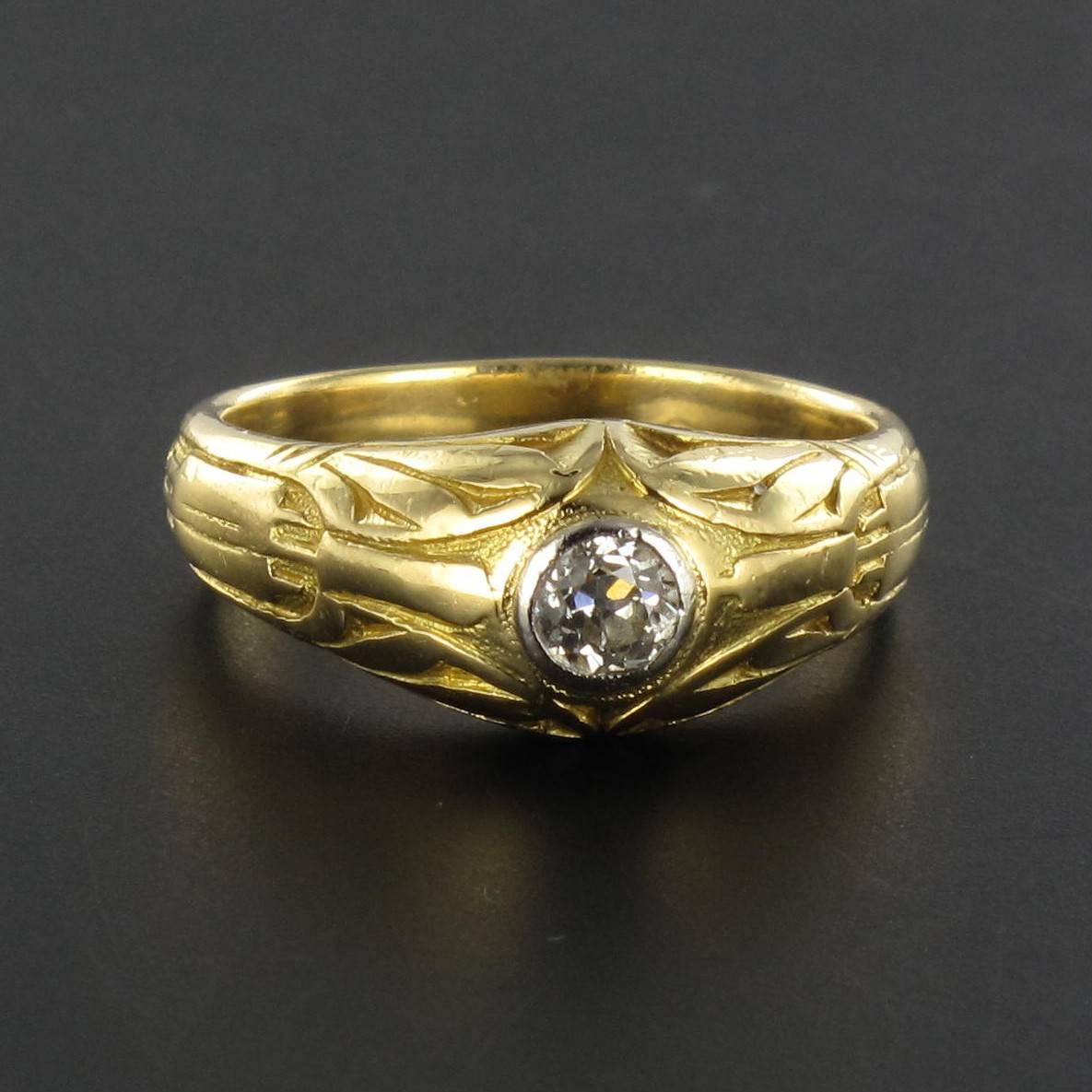 Ring in 18 carat yellow gold. 

A men’s gold signet ring, featuring a bezel set antique brilliant cut diamond of excellent quality set in white gold. The ring band is engraved over half of its surface with geometric forms around the central
