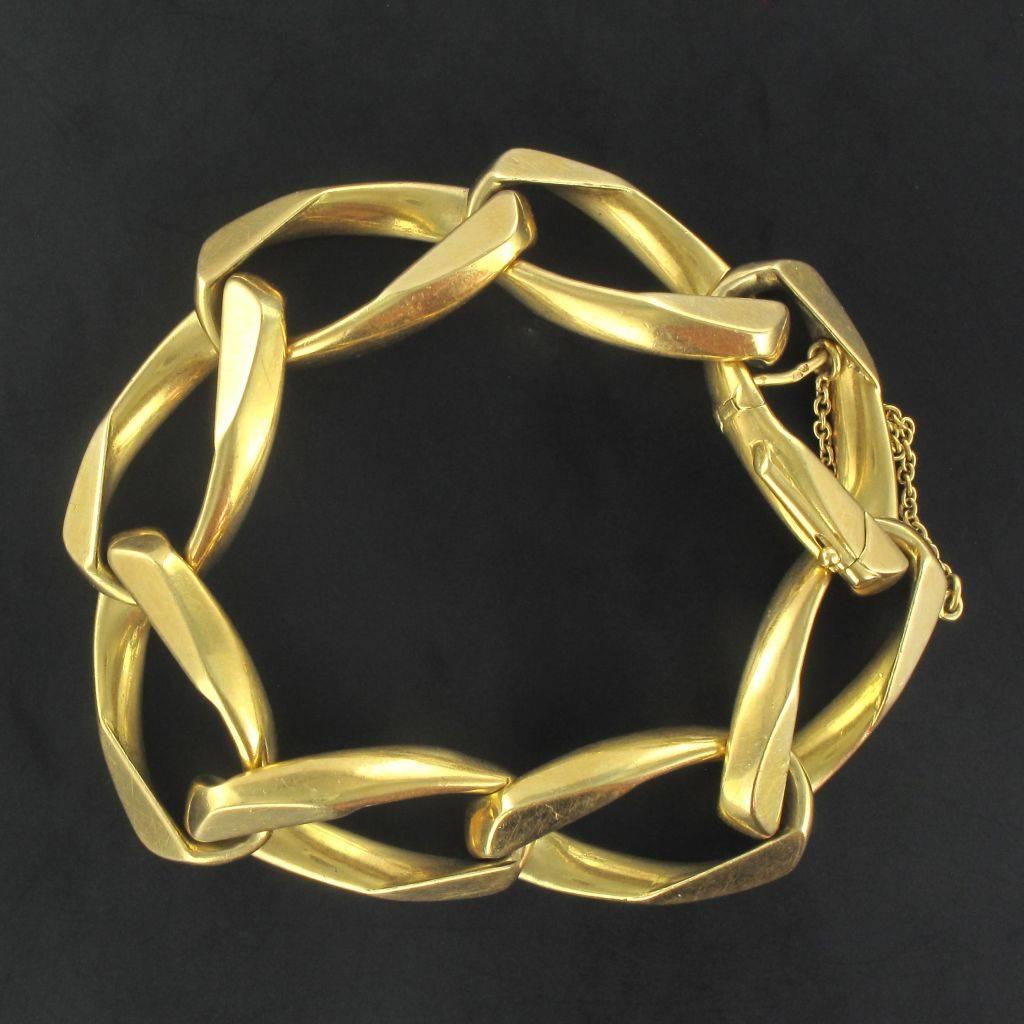 Bracelet in 18 carat yellow gold, eagle head hallmark. 
In the form of a brushed chain bracelet this piece of jewellery features 8 large oval connected links. The last link opens with a hook and pump with a safety chain. 
Width: 1.7 cm, length 3.2