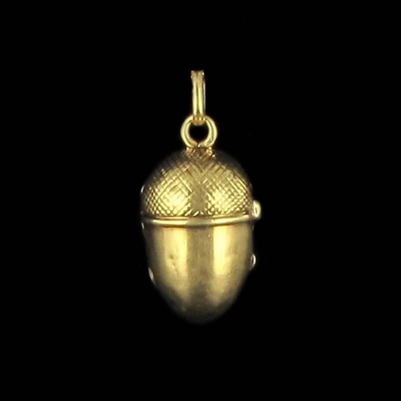 Pendant in 18 carat yellow gold, eagle head hallmark. 

This pendant in the form of a finely engraved acorn opens with a small hinge at the side with a gold encircled crystal screen inside that enables you to keep a small souvenir within such as a