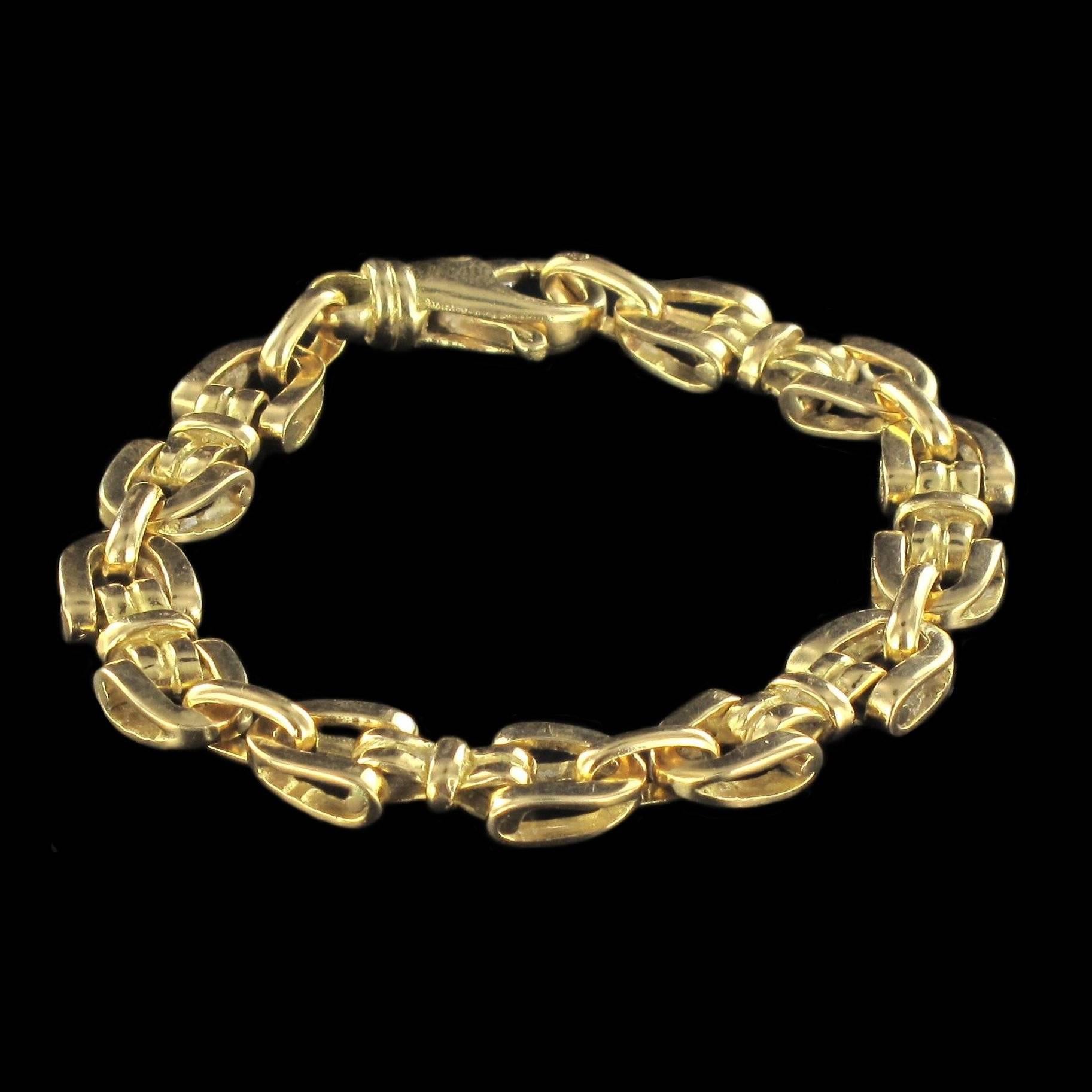 Bracelet in 18 carat yellow gold, eagle head hallmark. 

Composed of 12 motifs in the form of stirrups separated by a gold ring at one end and a bow at the other. This bracelet features a lobster claw clasp. 

Length: 18.2 cm, width at widest: