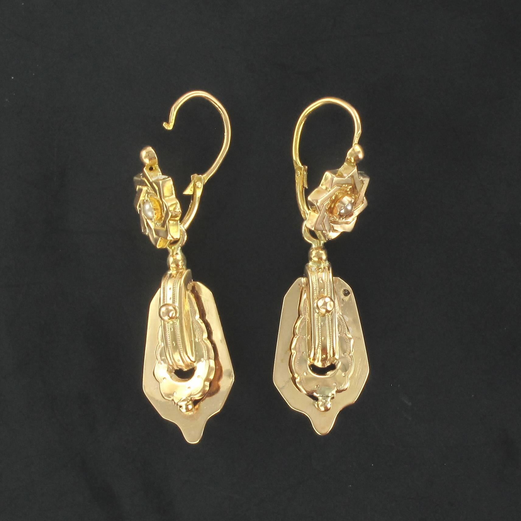 For pierced ears.

Pair of earrings in 18 carat rose gold, eagle head hallmark.

Each rose gold earring is composed of a star design set with a central fine pearl. A suspended rose gold openwork motif of finely chiselled gold with a claw set