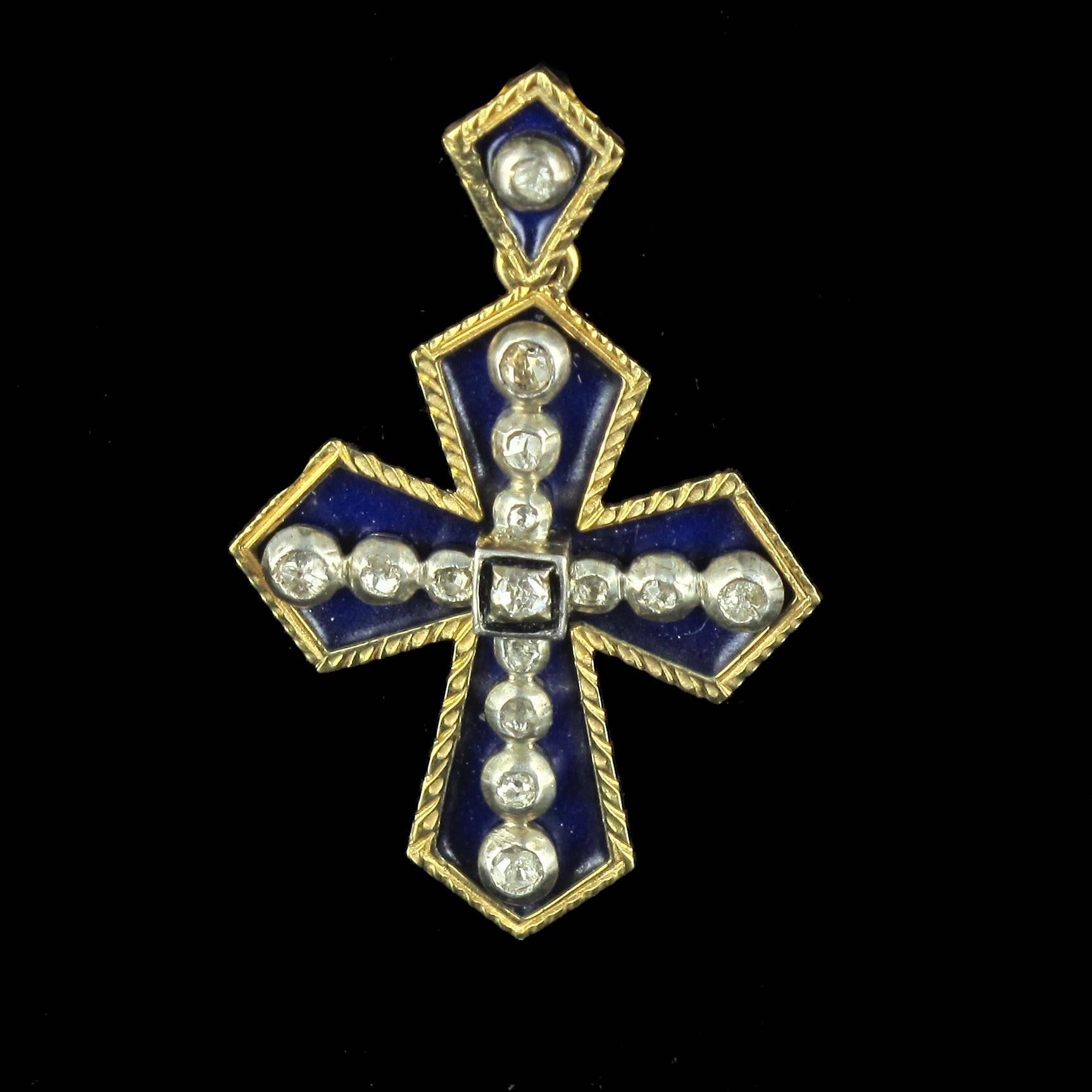 Cross in 18 carat yellow gold. 

This geometric style cross pendant features navy blue enamel and rose cut diamonds bezel set in silver. The bail is also enamelled and set with a rose cut diamond. The pendant back features engraved arabesques.