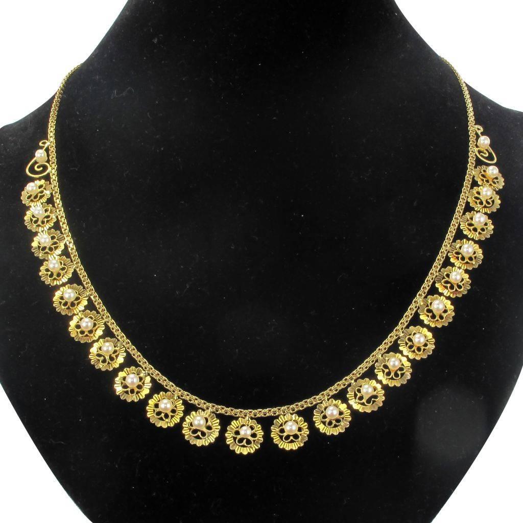 Necklace in 18 carat yellow gold. 

This delicate old necklace is made of a flat mesh chain on which are fixed circular openwork and chiselled motifs set in the center of a pearl of oriental white culture. The clasp is a spring ring with safety