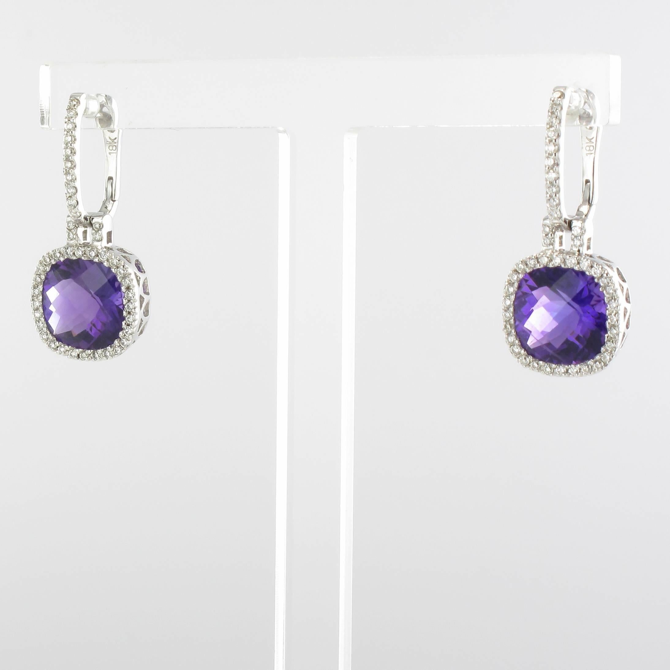 Earrings in 18 carat white gold, eagle head hallmark.

Each white gold earring is bezel set with a cushion cut amethyst surrounded by brilliant cut diamonds in an openwork setting decorated with arabesques. The earrings feature sleeper type