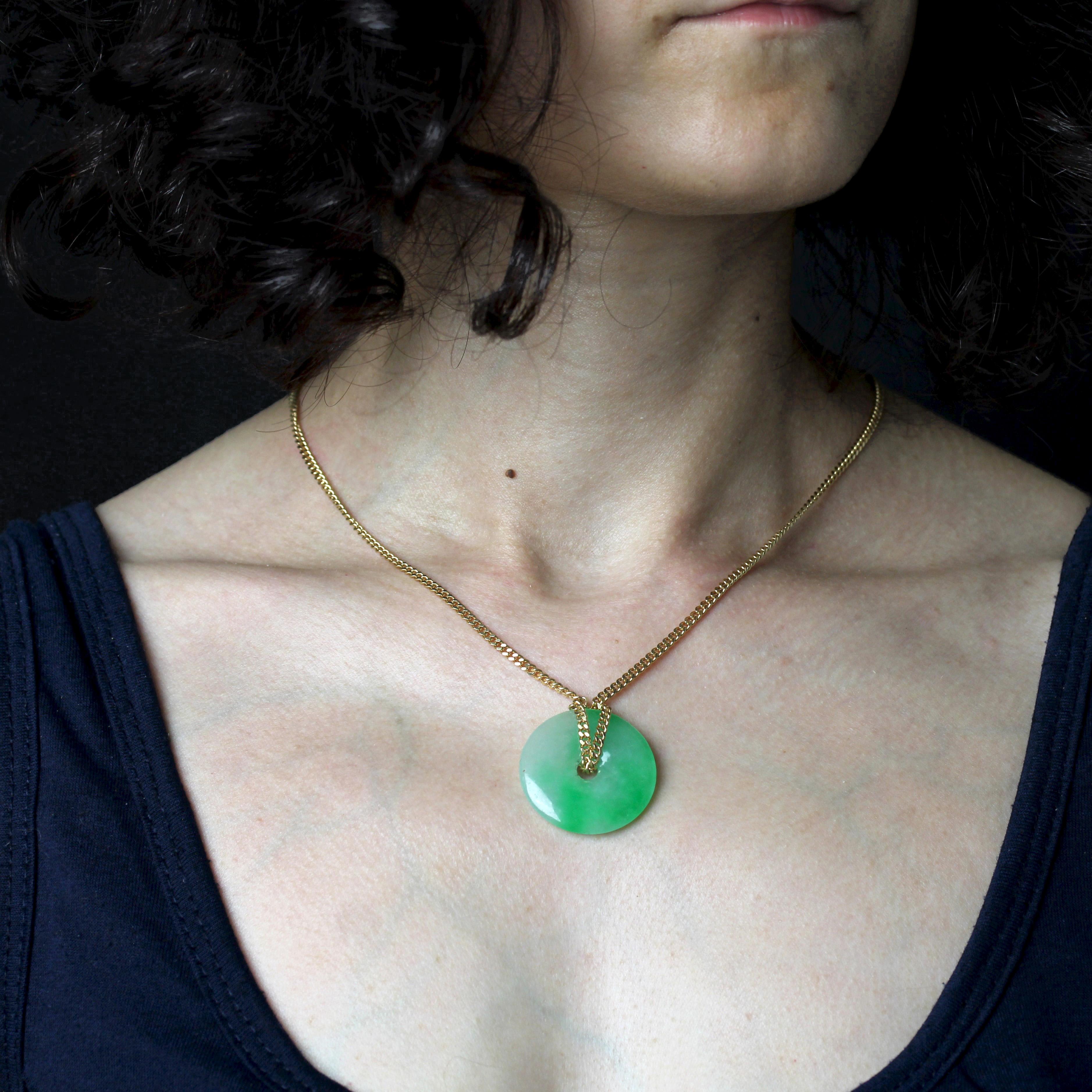 Chaîne en or jaune 18 carats, poinçon tête d'aigle.
La chaîne de ce collier en or jaune est un maillon gourmette limé qui retient un disque de jadeite vert nuancé de blanc grâce à un nœud coulissant amovible. Le nœud peut être retiré ou ajouté pour