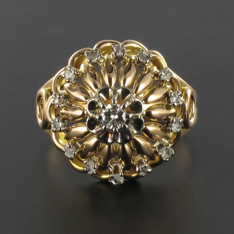 Yellow gold ring, 18 carats.

This beautiful round antique ring is claw set with a brilliant cut diamond set within an openwork design of gold palm leaves. The surrounding rose cut diamonds complete the design. The ring bed features gold strands and