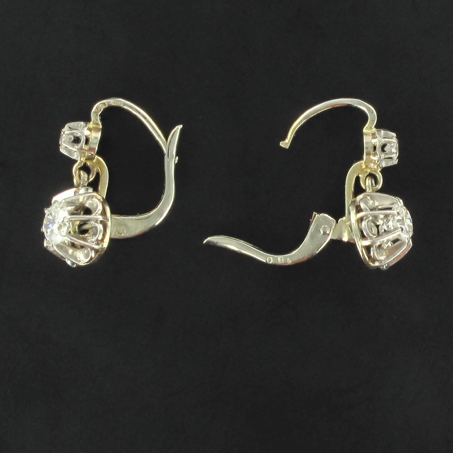 For pierced ears.
Pairs of earrings in 18 carat white gold, eagle head hallmark. 

Each diamond earring features a claw set brillant cut diamond from which is suspended a much larger brillant cut diamond in an illusional setting. The clasp closes at