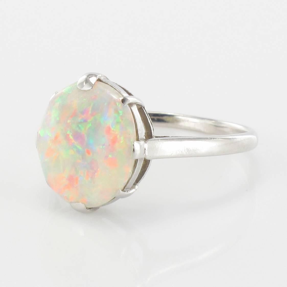 Platinum ring, dog's head hallmark.

This stunning ring is claw set with a natural Australian opal cabochon that is slightly oval in shape. The ring bed is openwork thereby allowing light to enter and illuminate the opal. 

Total weight of the opal: