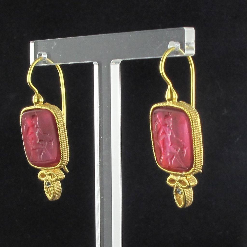 For pierced ears.

Pair of earrings in vermeil, silver and yellow gold.

Drop earrings are set by a red cameo on glass paste and 1 crystal. The clasps are goosenecks with safety hooks. 

Height: 3,8 cm, width at the cameo: 1,5 cm.
Total weight : 9,1
