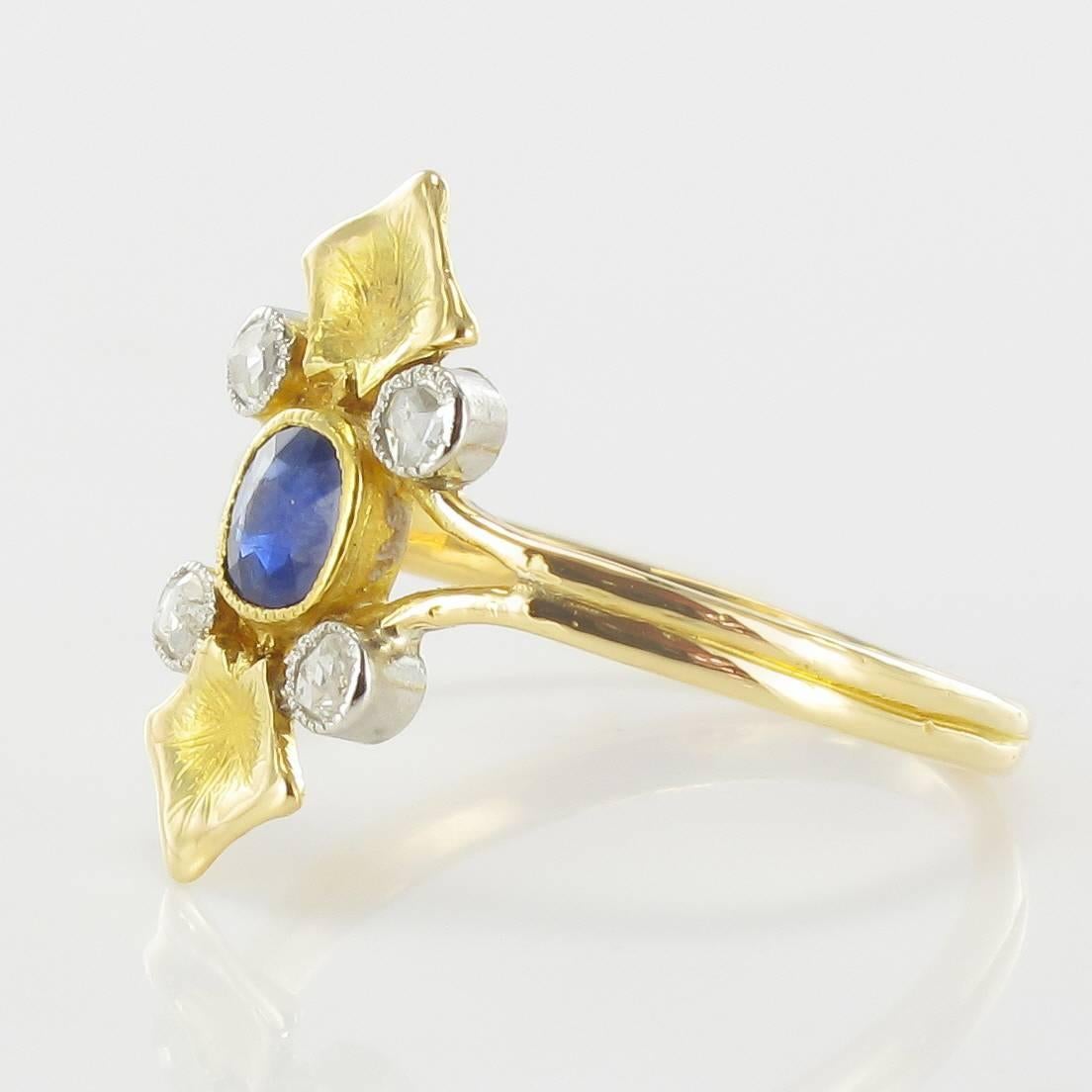 Ring in 18 carat yellow gold, eagle head hallmark. 

This gorgeous antique ring is bezel set with an oval sapphire with a beaded surround with 4 brilliant cut diamonds bezel set at its cardinal points also in beaded settings. Two finely engraved
