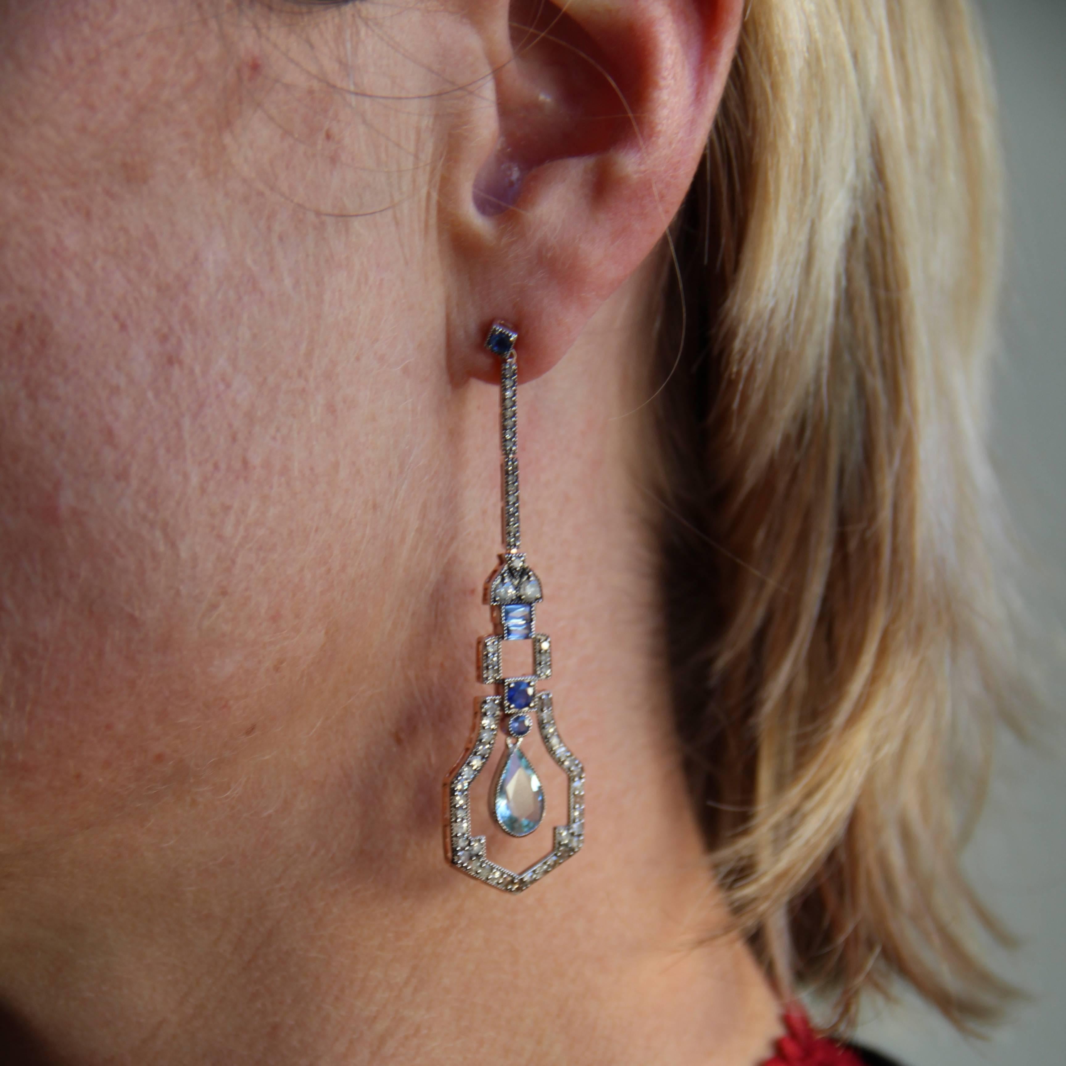 For pierced ears.
Earrings in vermeil, silver and rose gold.
Inspired by Art Deco lines, these earrings are made of a blue sapphire that holds a double articulated line set with rose-cut diamonds, which itself retains a geometric motif set with