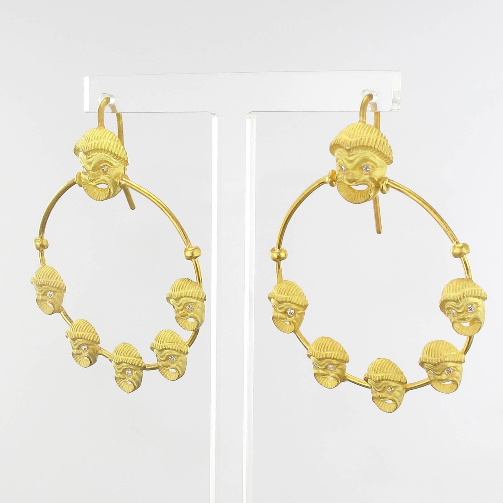 For pierced ears.
Earring in matte vermeil.
These splendid vermeil earrings are made of a delicately chiseled grinning mask whose eyes are set with small crystals. It retains a large gold ring set with applied same motif in mask. The hanging system