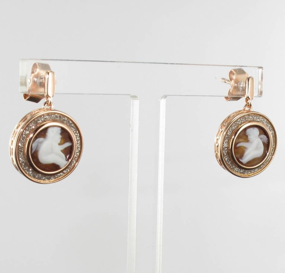 For pierced ears.
Earrings in vermeil, silver and rose gold.
Adorable earrings, each one is composed of a small rectangular motif which retains a cameo on shell representing an enclosed cherub surrounded by small crystals. The basket is openwork.