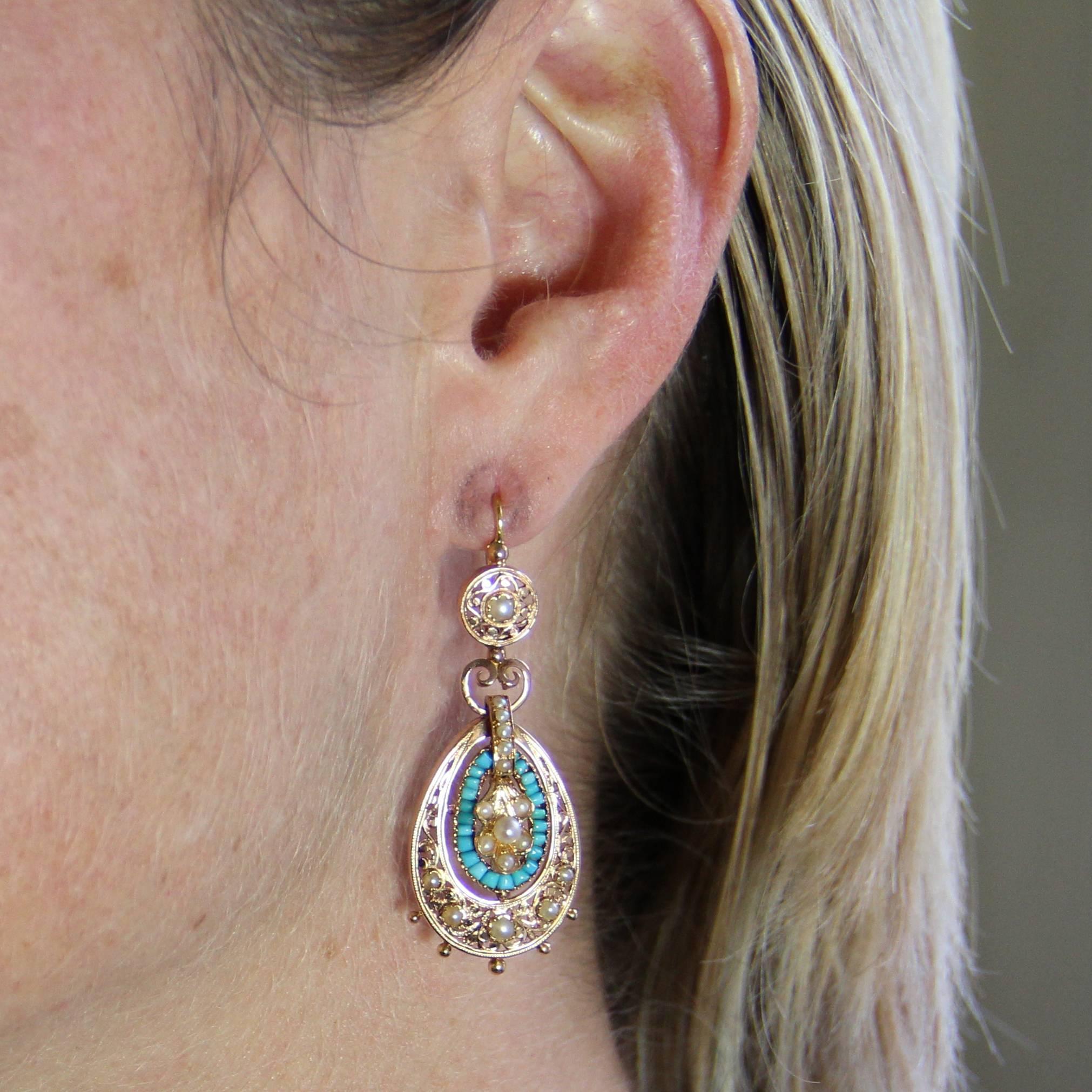 Earrings in 18 carats yellow and rose gold, eagle's head hallmark.
Splendid pendant earrings, each consists of a gold engraved disc set in the center of a half natural pearl and which supports a drop motif surmounted by a heart motif interconnected