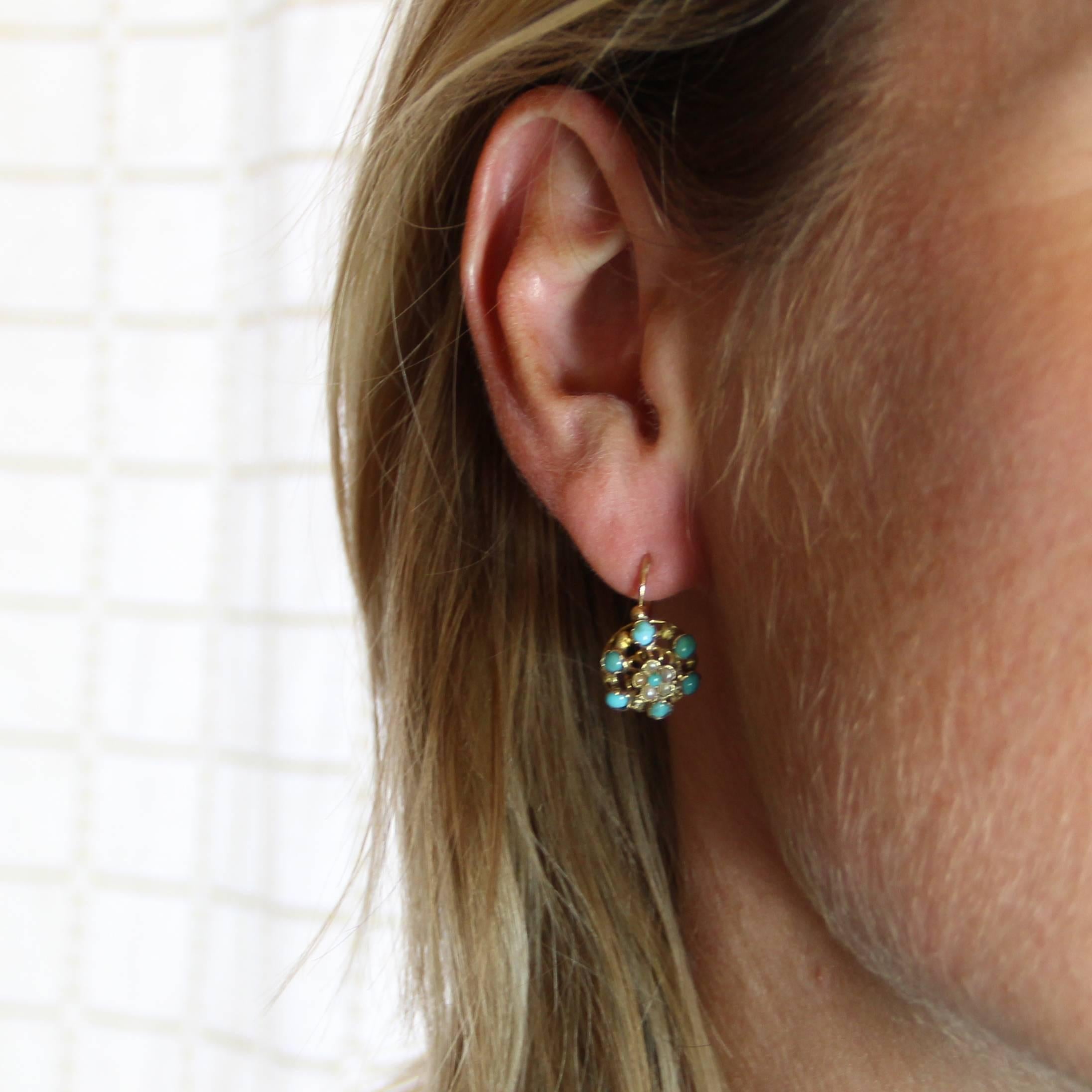 For pierced ears.
Earrings in 18 carats yellow gold, eagle's head hallmark.
Beautiful drop earrings, each one is set with 5 half pearls and centered with a turquoise cabochon. The openwork decoration is set with 6 turquoise cabochons. The clasp