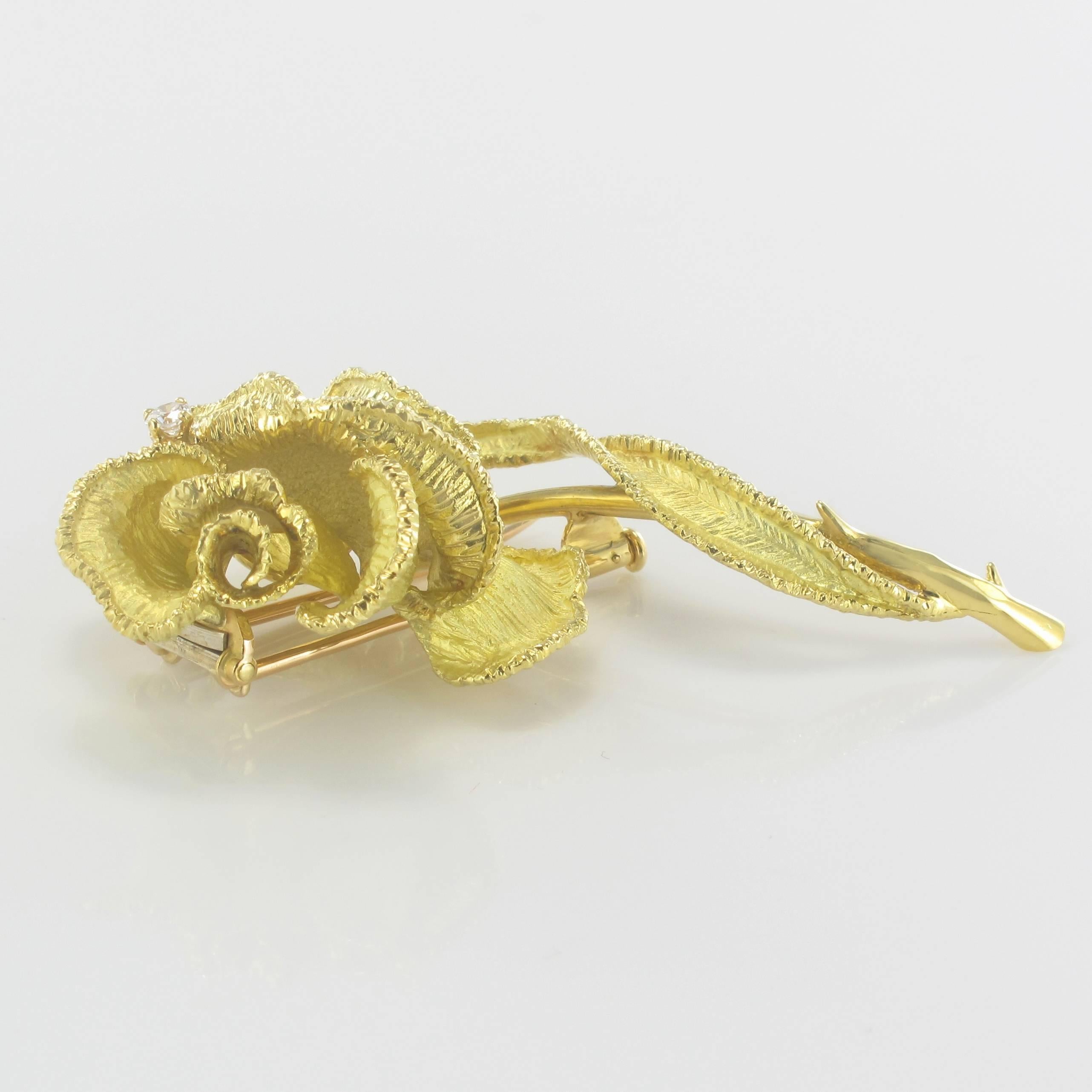 Brooch in 18 carats yellow gold, eagle's head hallmark.
Representing a just hatched rose, this beautiful vintage brooch is set with 4 claws of a brilliant cut diamond on a chiseled decor. The clasp is made by a double pin with safety pump.
Total