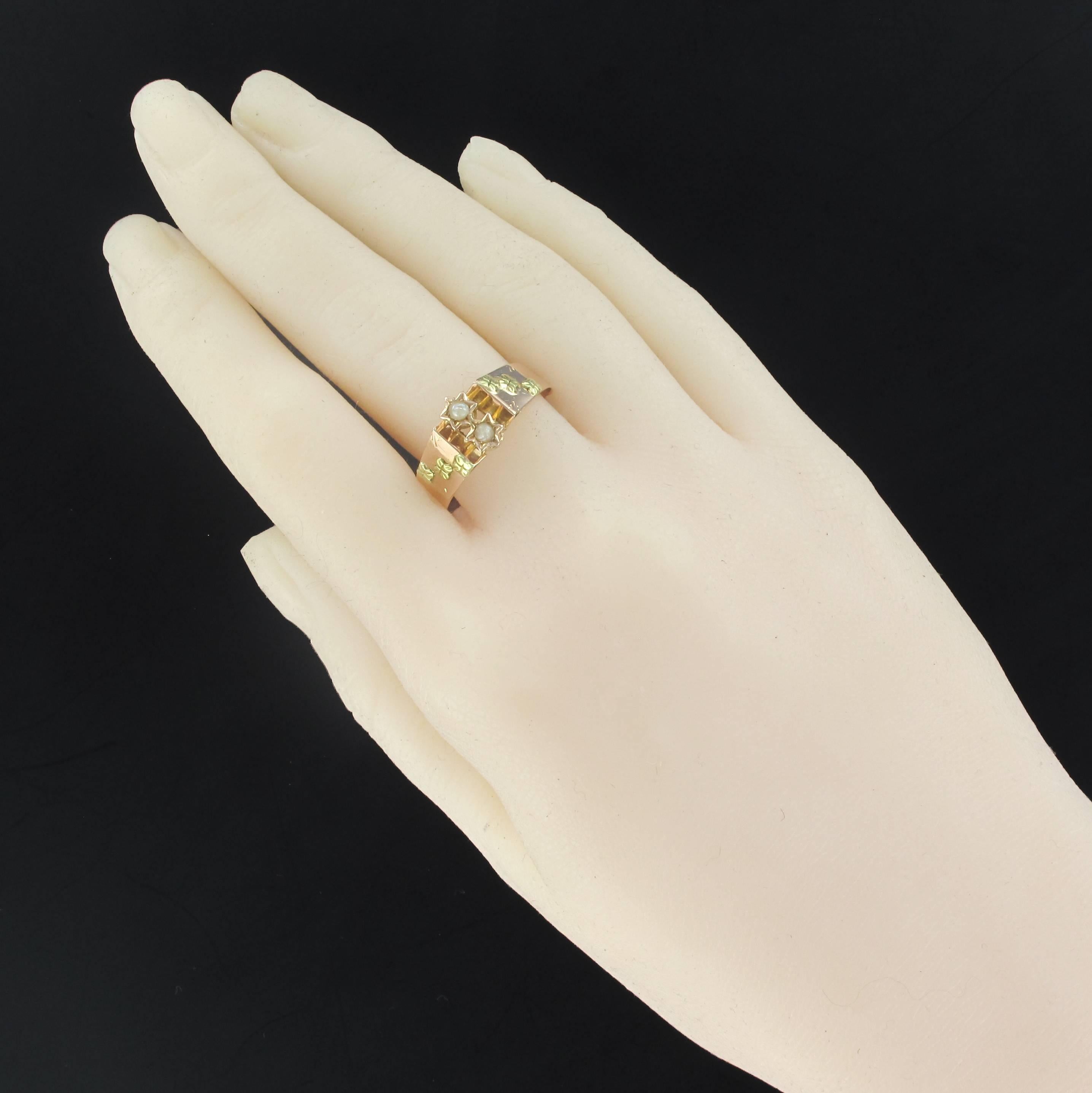 Ring in 18 carats rose and green gold, horse's head hallmark.
This beautiful antique ring is set on its top with 2 half natural pearls star set. On both sides, the start of the ring is set with 3 green gold flowers.
Height: 8.9 mm, width: 18.6 mm,