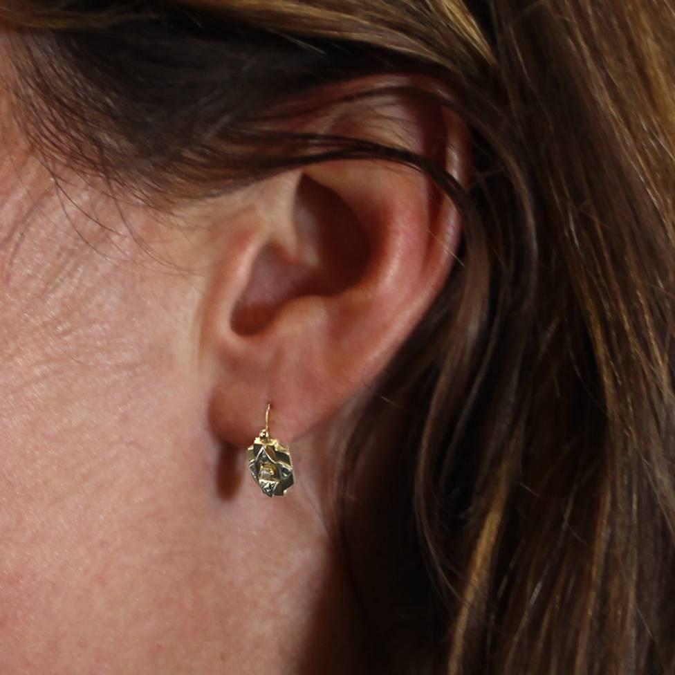 For pierced ears.
Earrings in 18 carats yellow and white gold, eagle's head hallmark.
Lovely sleeper earrings, each consists of a decoration in two shades of gold chiseled and set in the center of a half natural pearl. The clasp is on the