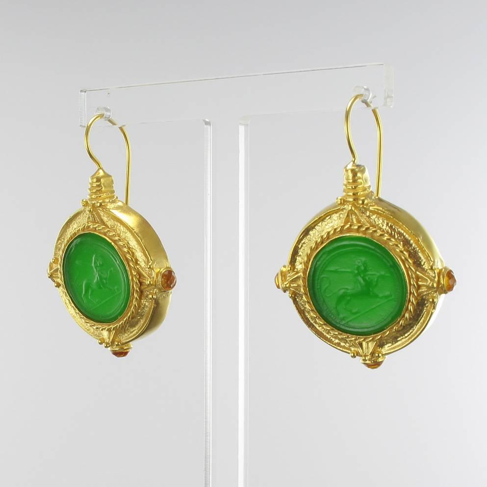 For pierced ears.
Pair of earrings in vermeil, silver and yellow gold.
Drop earrings are set by a green cameo on glass paste. The clasps are goosenecks with safety hooks. 
Height: 4,3 cm, width at the cameo: 2,9 cm.
Total weight : 8,2 g