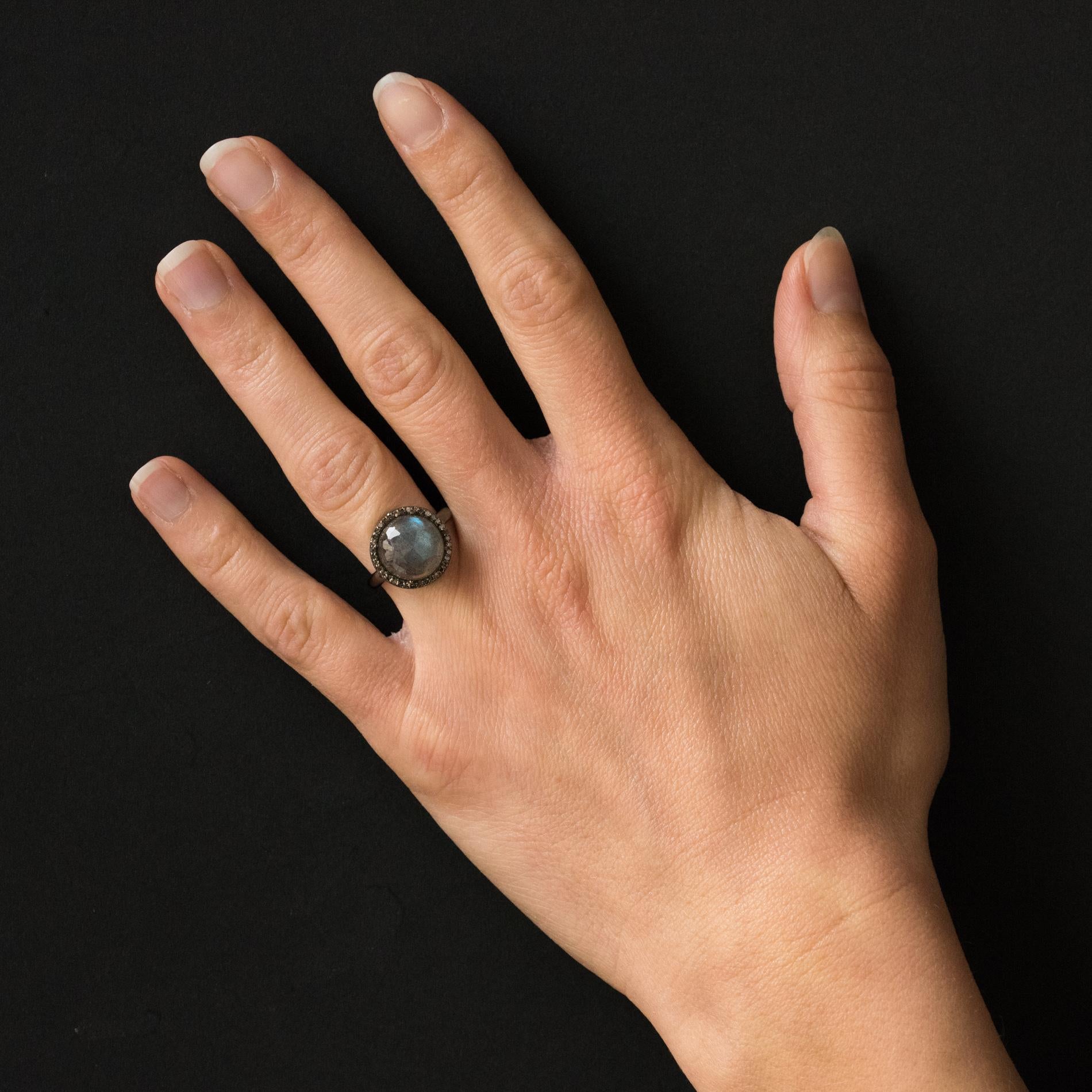 Ring in silver, black rhodium.
Lovely ring of round shape, it is set in the center with 4 claws of a cabochon faceted labradorite surrounded by small diamonds.
Diameter: 1.4 cm, thickness: 7 mm.
Width of the ring at the base: 2.5 mm.
Total weight of
