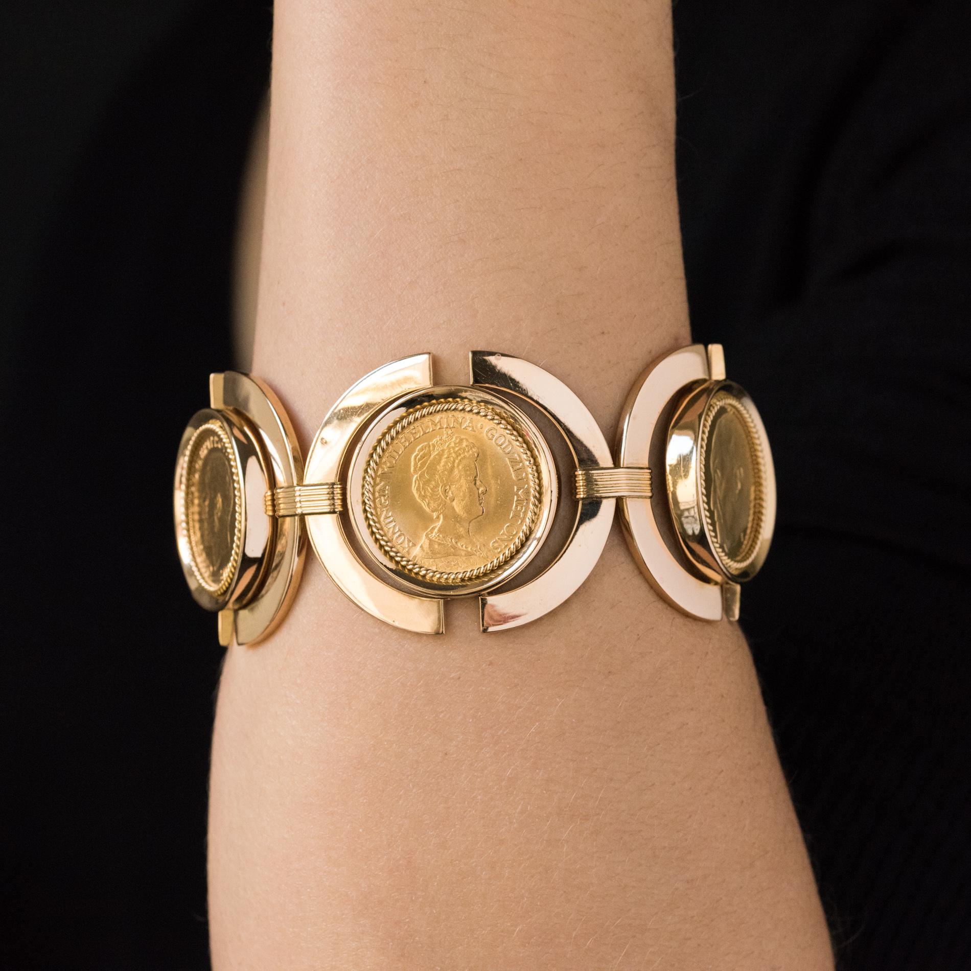 Bracelet in 18 karats yellow gold.
Bulky vintage bracelet, it is composed of 5 round-shaped motifs linked together by gold staples. At the center of each motif, is set on a mobile kitten, a gold coin lined with a gold cord. The coins are 1 of 20