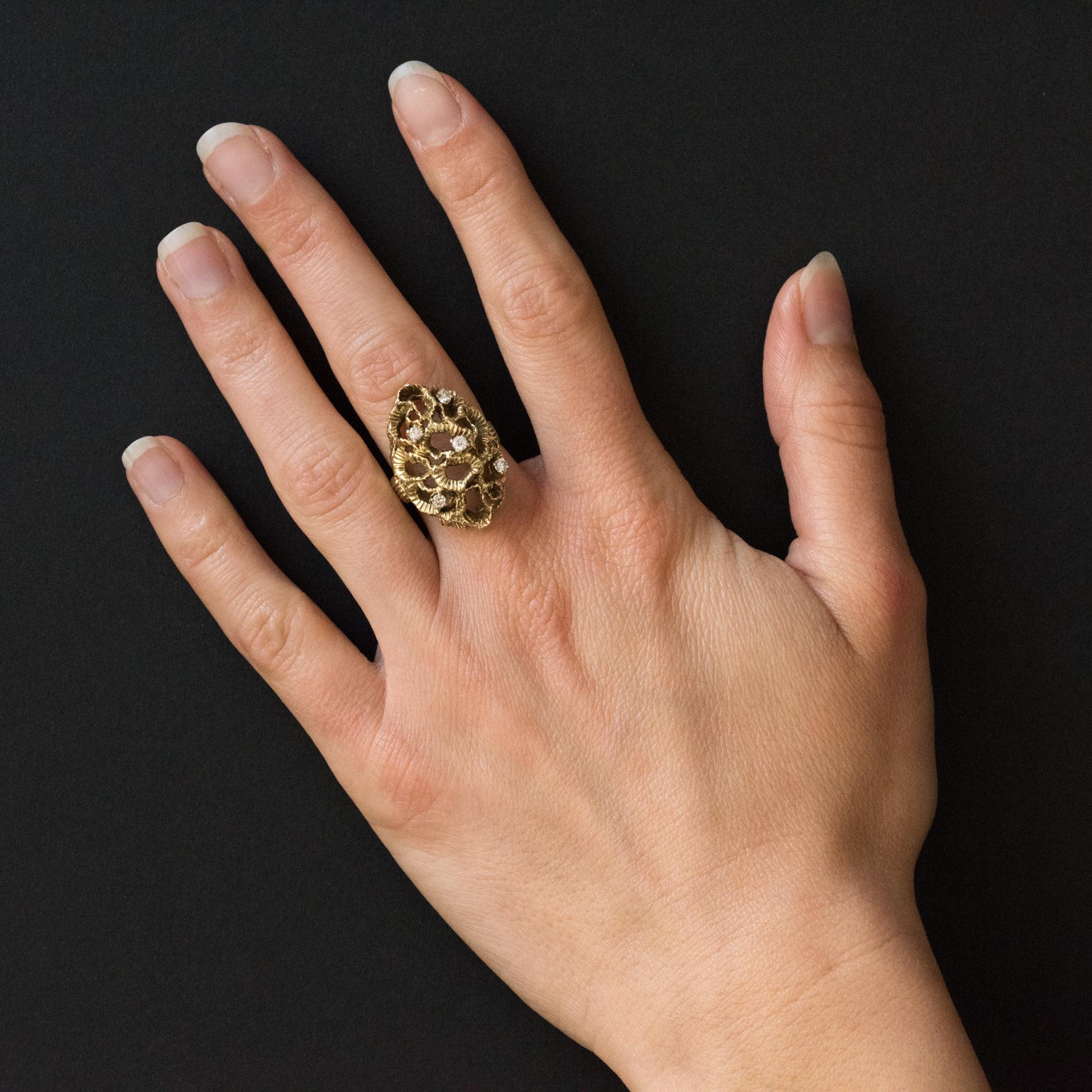 Ring in 14 karats yellow gold.
This voluminous ring with modernist lines is set with claws of 5 brilliant-cut diamonds in a domed, openwork and chiseled decoration like a drapery.
Diamond weight: 0.22 carat approximately.
Height: 2.6 cm, width: 1.5