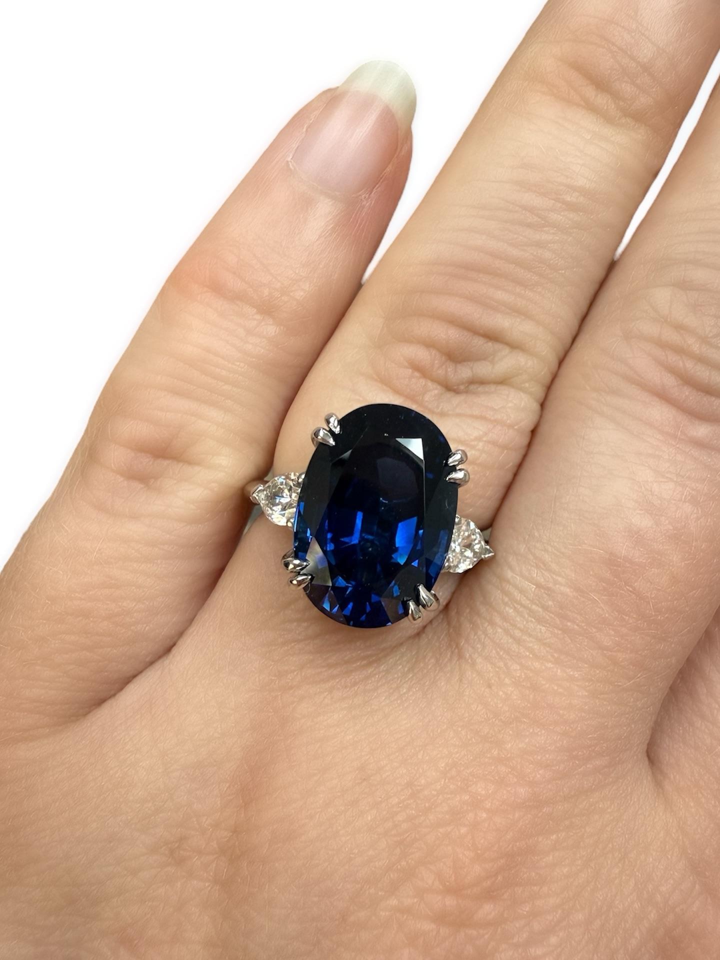 Dieser atemberaubende Ring enthält einen ovalen Saphir im Mischschliff mit einem Gewicht von 9,77 Karat und einer Größe von 14,83 x 10,41 x 7,22 mm, flankiert von zwei birnenförmigen Diamanten mit einem Gesamtgewicht von 0,84 Karat. Eingefasst in