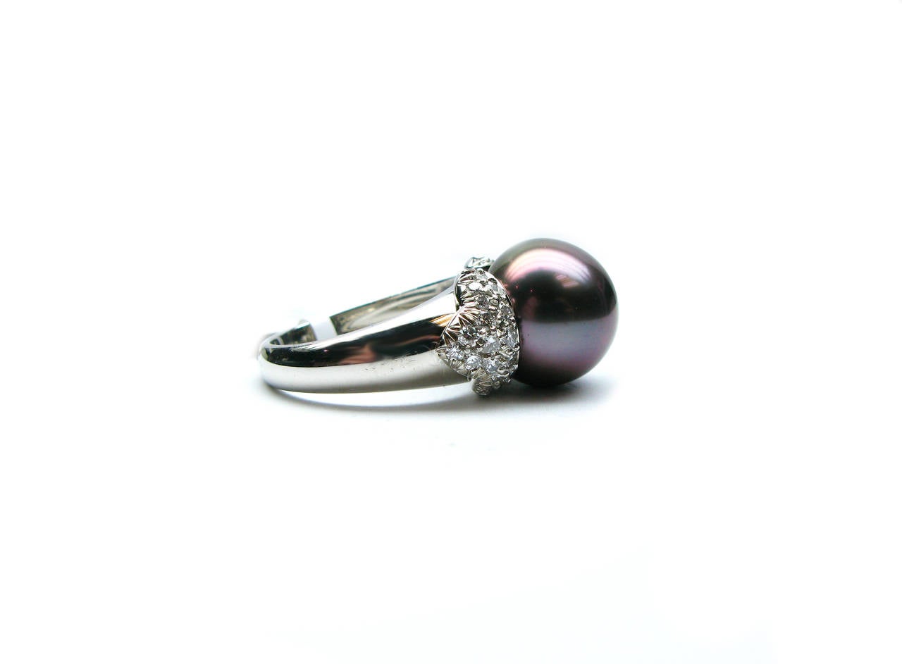 One-of-a-kind platinum ring from the Kurt Wayne collection. This gorgeous cocktail ring features a 12.7mm black pearl center with 0.68ctw pave set round brilliant diamond accents on either side.