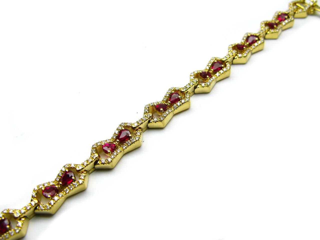 One-of-a-kind 18kt yellow gold bracelet from the Kurt Wayne collection. This beautiful bracelet features 1.32ctw of round brilliant diamonds set in frames around 4.96ctw of pear shape faceted ruby gemstones. This stunner is as unique as the woman