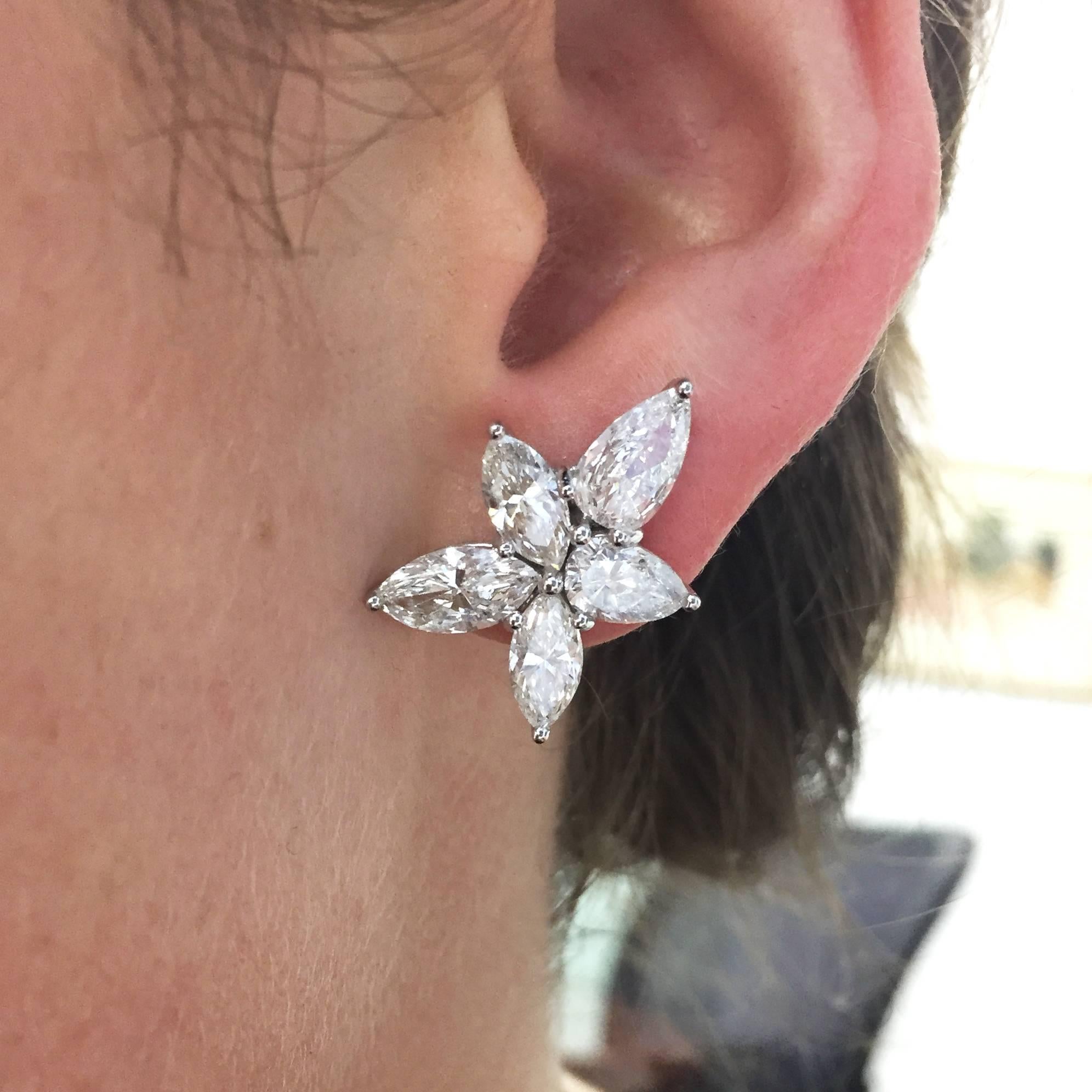 Chic yet sparkly diamond cluster earrings consisting of 10 pear-shaped diamonds weighing 7.36 carats total, each with F color and SI1 clarity. The diamonds are set into 18k white gold floral cluster-style mountings. Earrings are pierced and secure