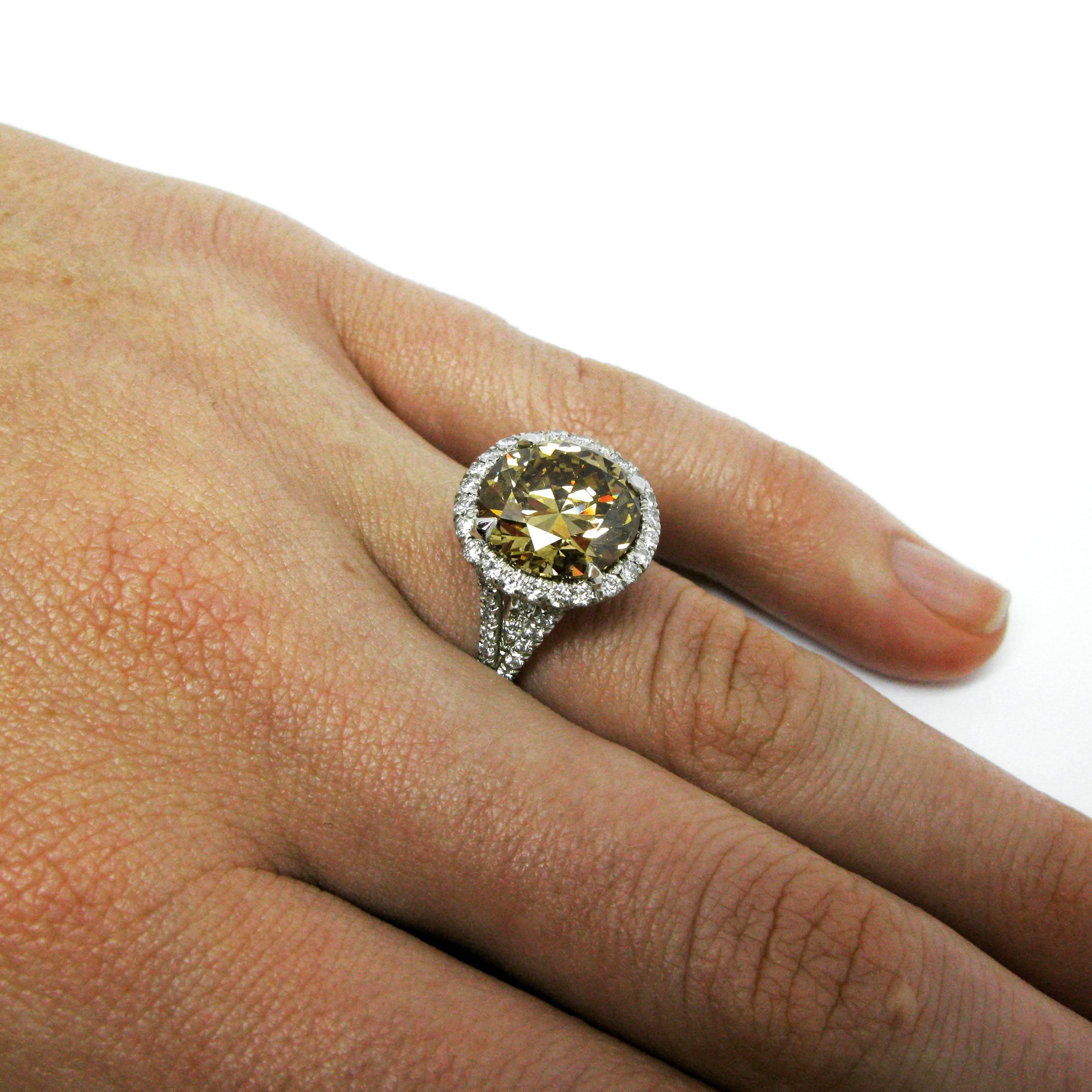 A contemporary ring centers around a 5.02 carat round brilliant-cut diamond with Fancy Brownish Yellow color and SI2 clarity. This beauty is set in a platinum split-shank frame mounting accented with pave diamonds.

Purchase includes a GIA Diamond