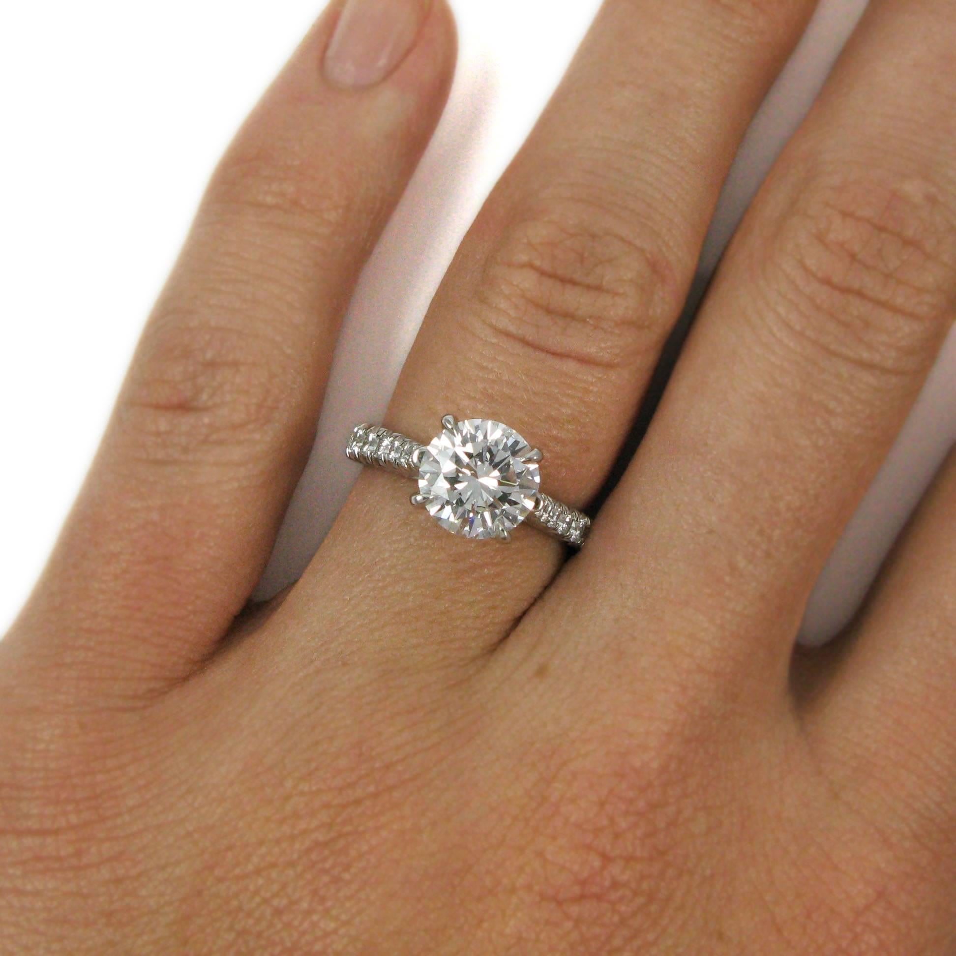 A real sparkler! This stunning platinum ring features a 2.01 carat round brilliant-cut diamond with D color and VS1 clarity. The diamond is claw-set into a high basket setting, and the mounting is accented by approx. 1.15 carats of graduated round