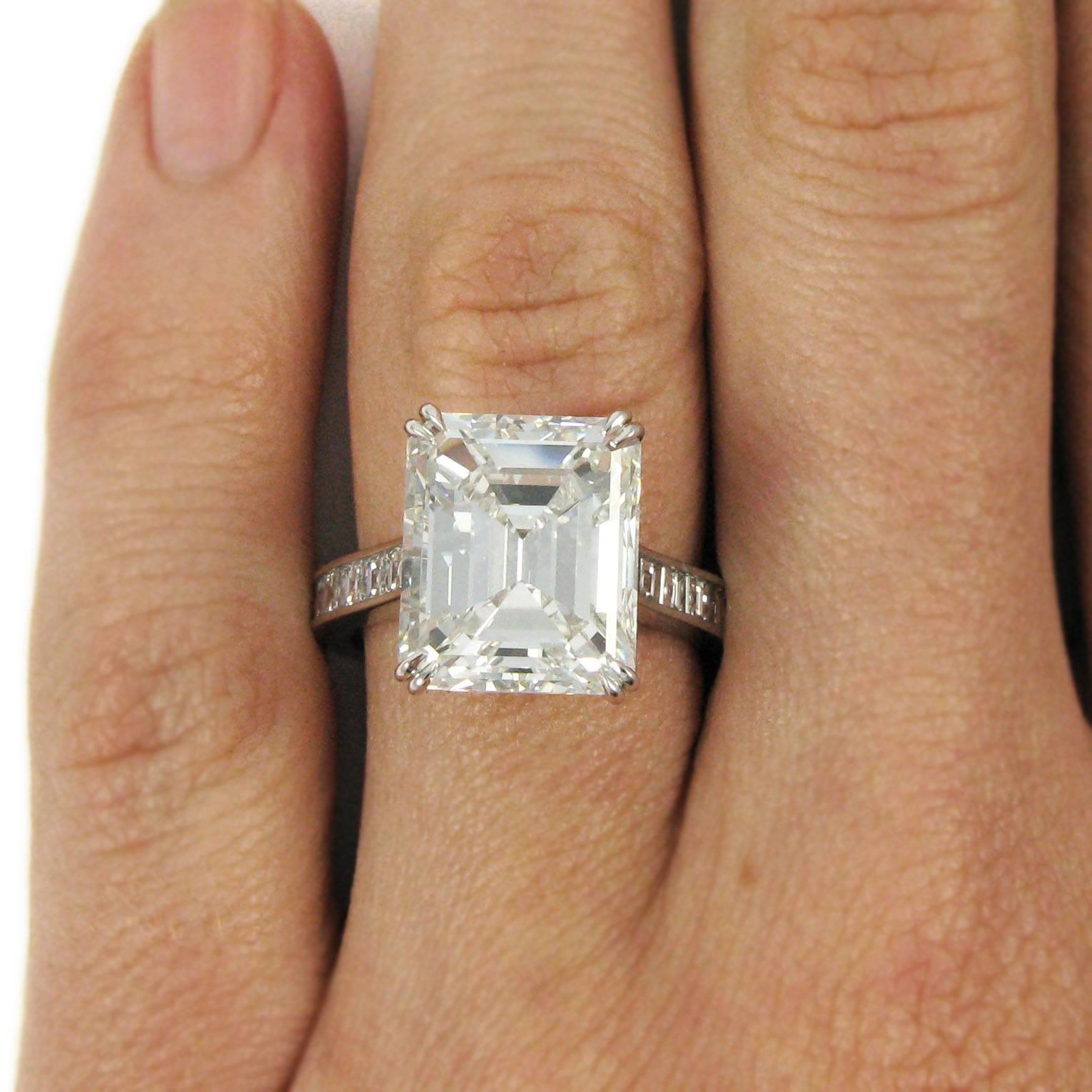 A stunning update to the classic solitaire. This platinum ring features a beautiful 7.18 carat emerald-cut diamond with F color and VS2 clarity. The diamond is set in a simple double-claw basket and is mounted on a streamlined cathedral ring shank