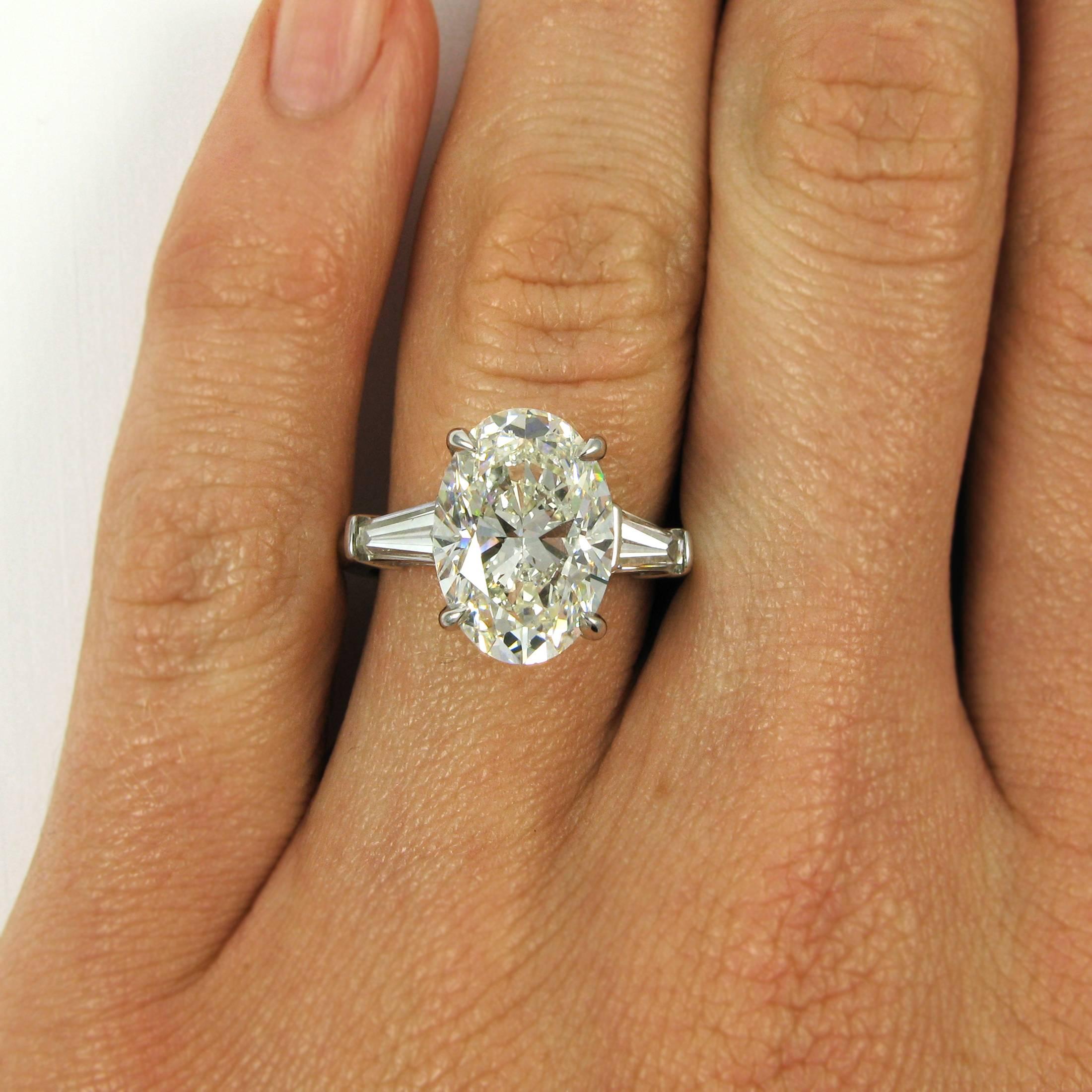 A stunning classic ring centering on a 5.01 carat oval-cut diamond with I color and SI1 clarity flanked by two tapered baguettes totaling approx. 1.10 carats. Mounted in platinum. 

Accompanied by GIA Diamond Grading Report 5151882302, which states