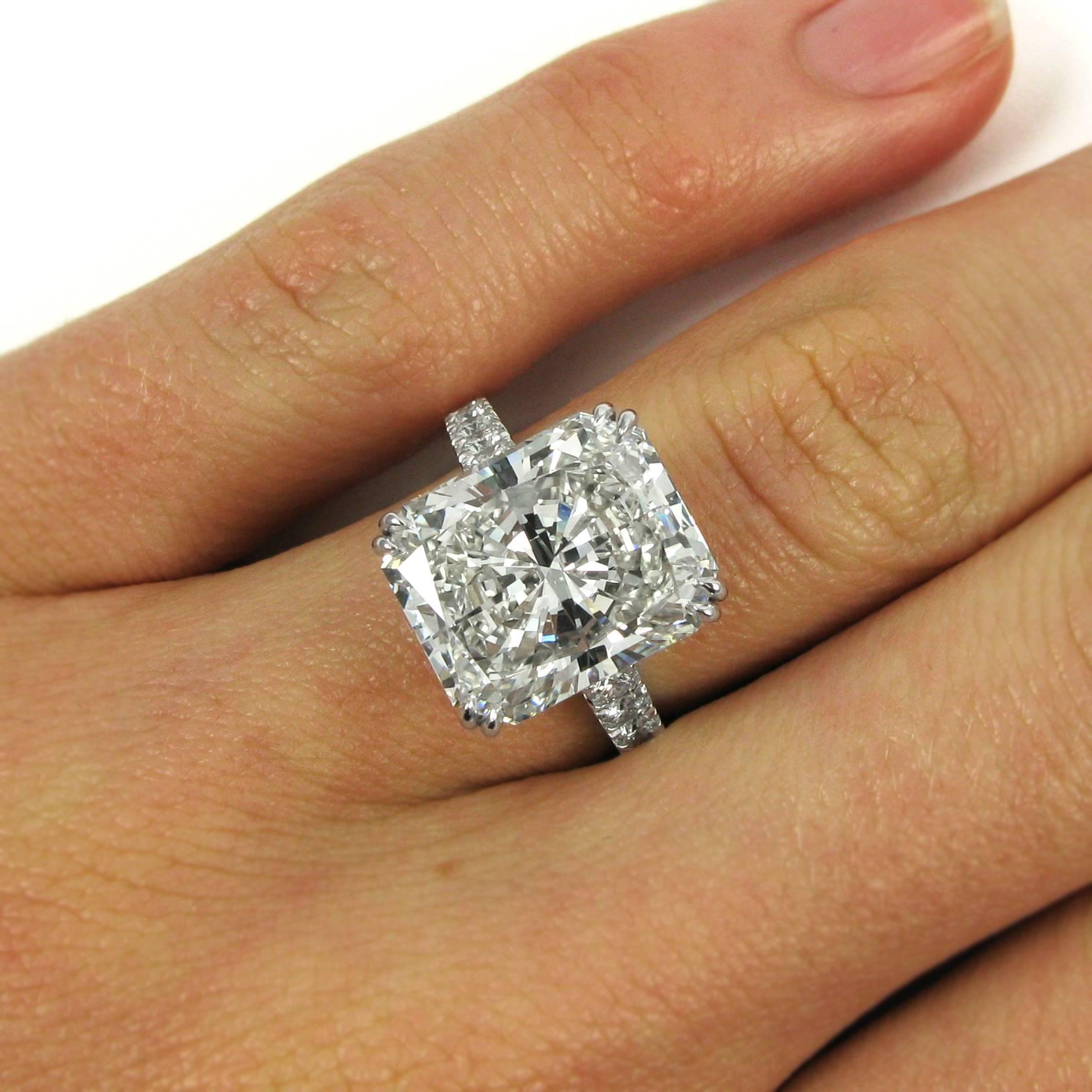 A scintillating and important ring centering on a 10.04 carat J. Birnbach radiant-cut diamond with J color and VS2 clarity. This beautifully-cut stone is set in a double-claw basket atop a cathedral ring shank set with 18 round brilliant-cut