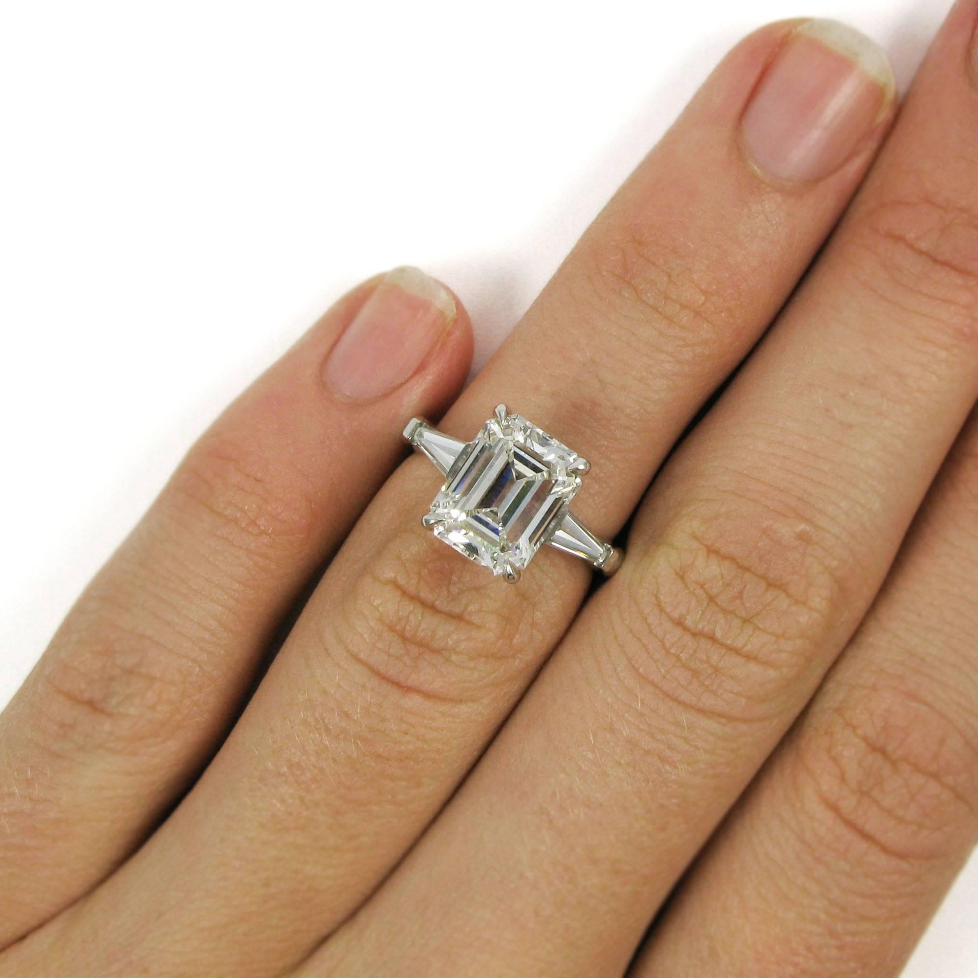 Classic and lovely! This platinum ring features a 3.24 carat emerald cut diamond in claw prong settings flanked by two bar-set tapered baguettes totaling approx. 0.62 carat. 

Purchase includes GIA Diamond Grading Report 5171582087, which states